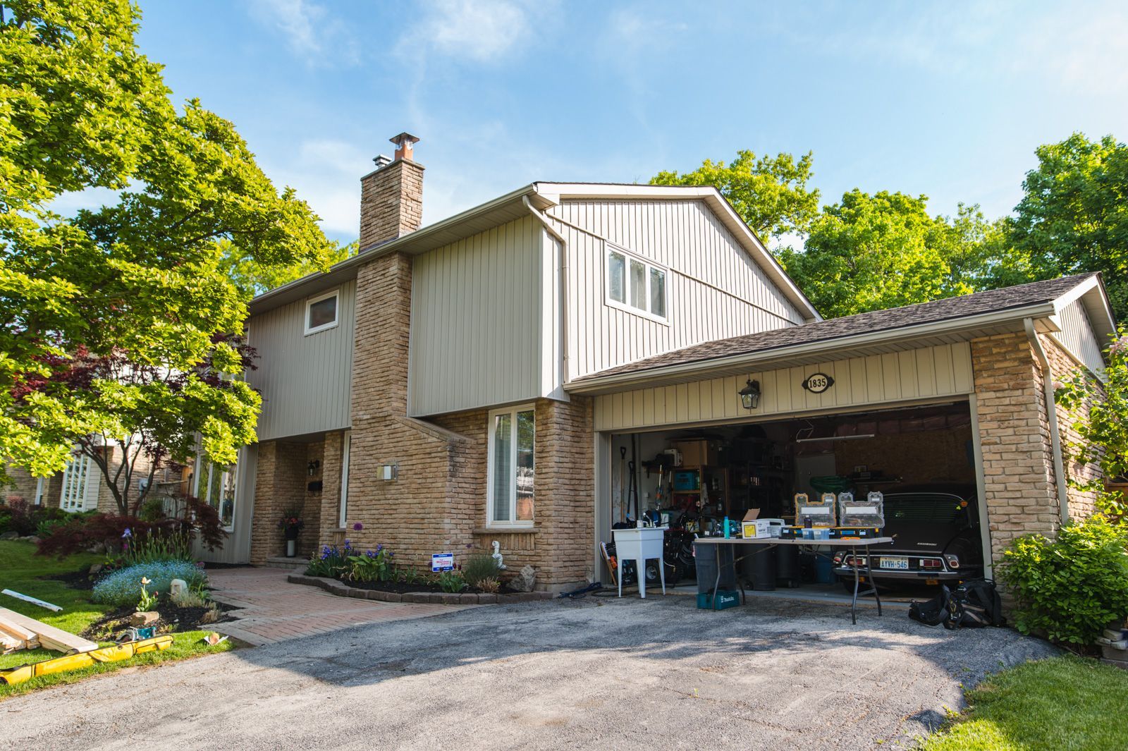 A large brick house with a garage and a table in front of it.