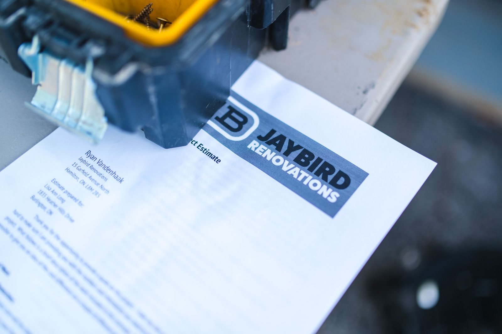 A piece of paper that says jaybird renovations is sitting on a table next to a toolbox.