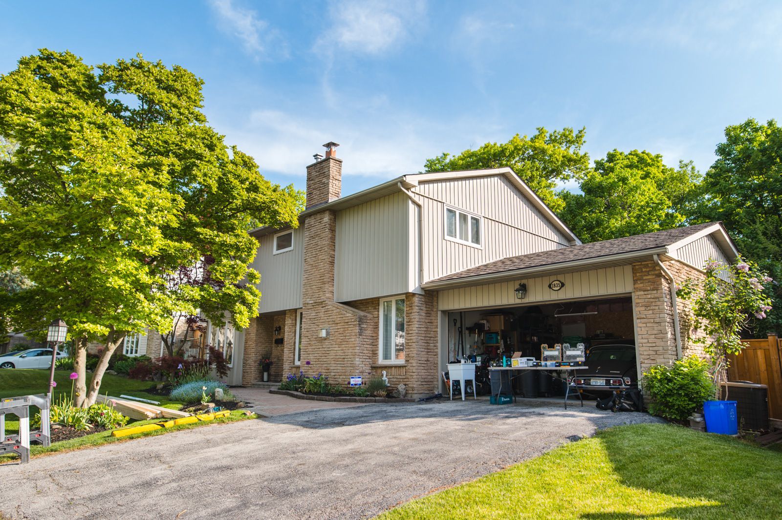 A brick house with a garage and a driveway in front of it.