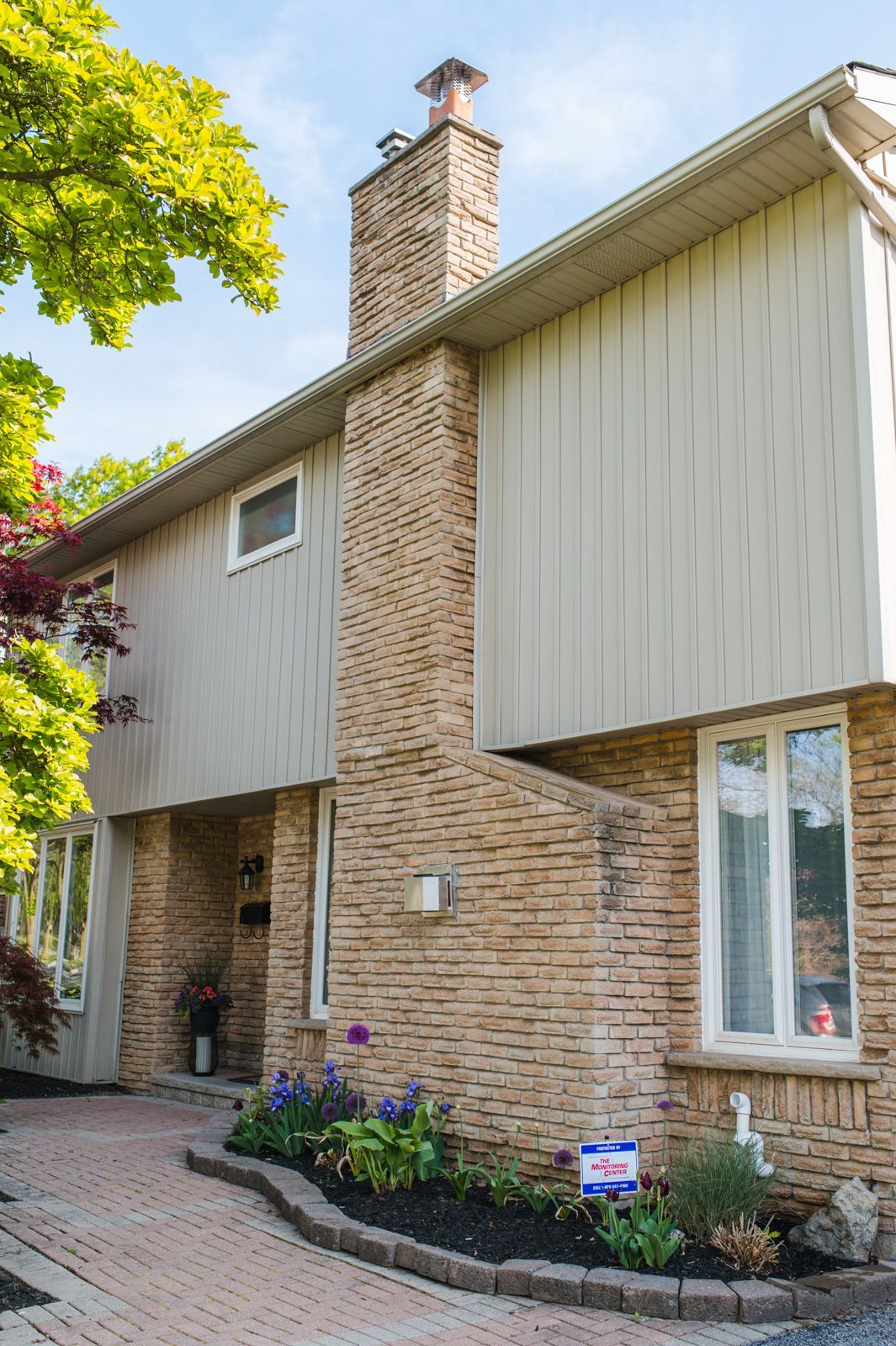 A large brick house with a chimney on the side of it