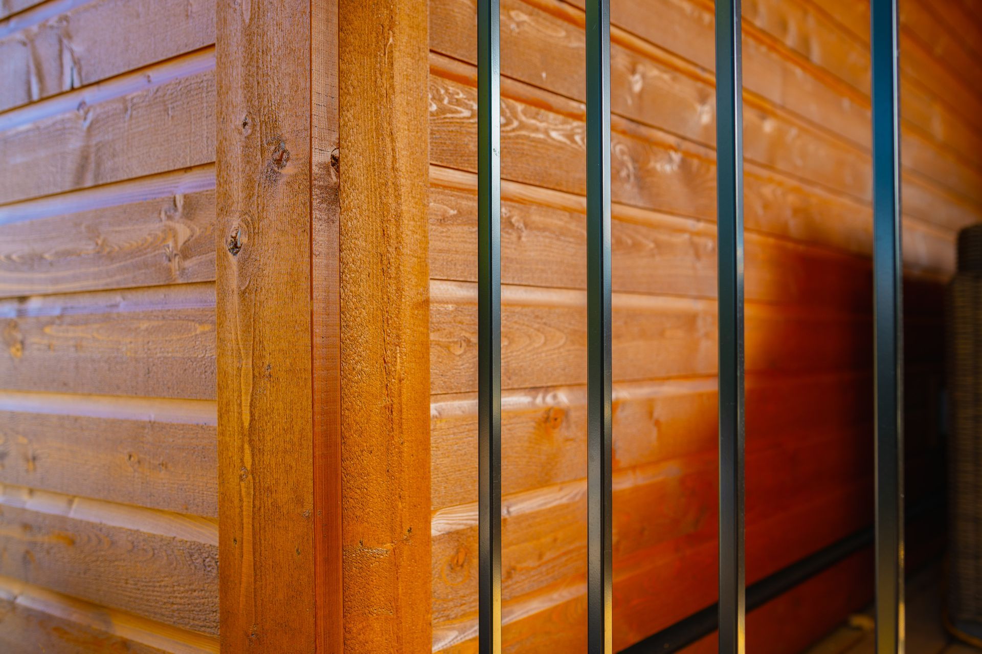 A close up of a wooden wall with a metal railing.
