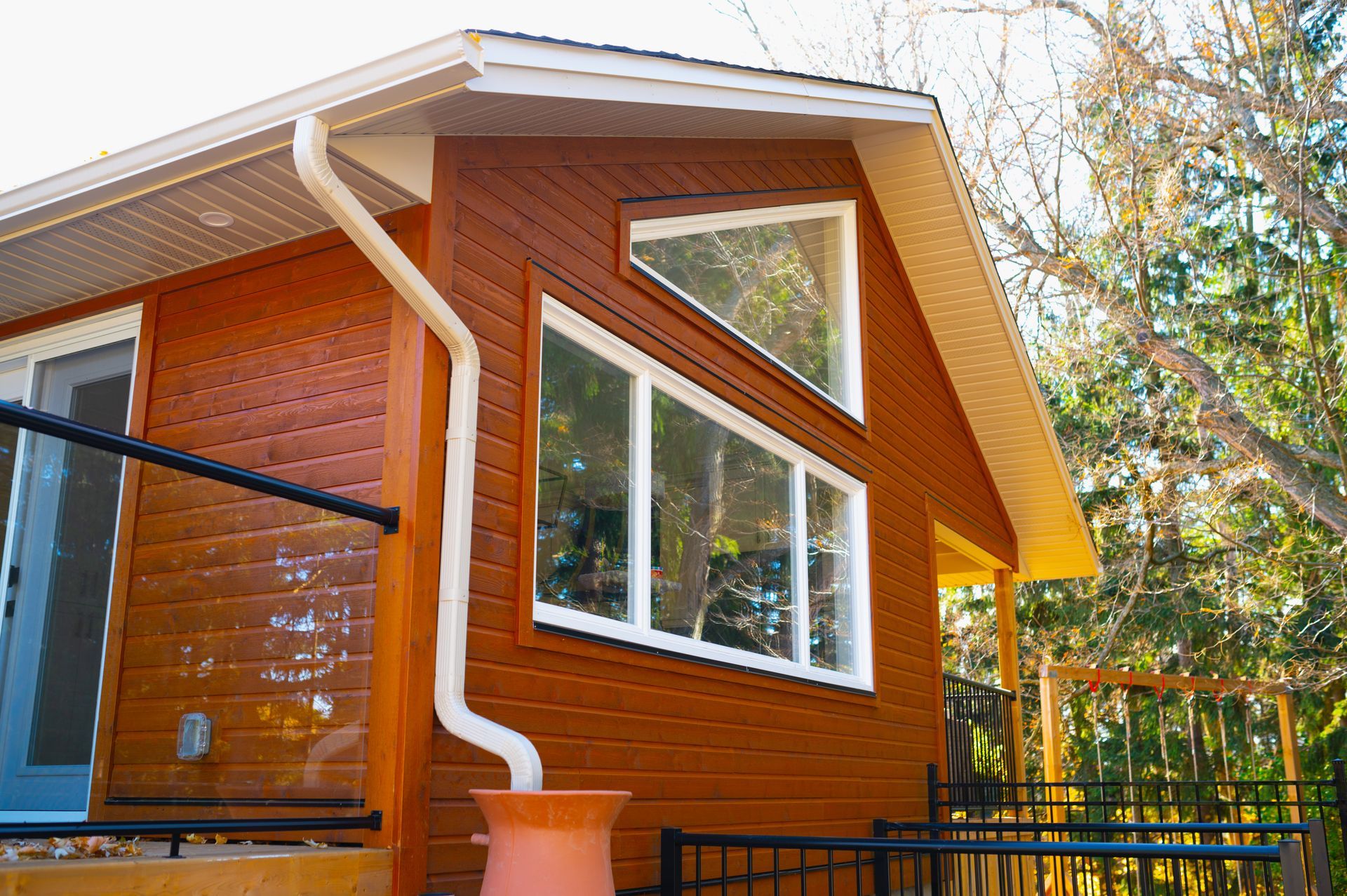 A small brown house with a white gutter on the side