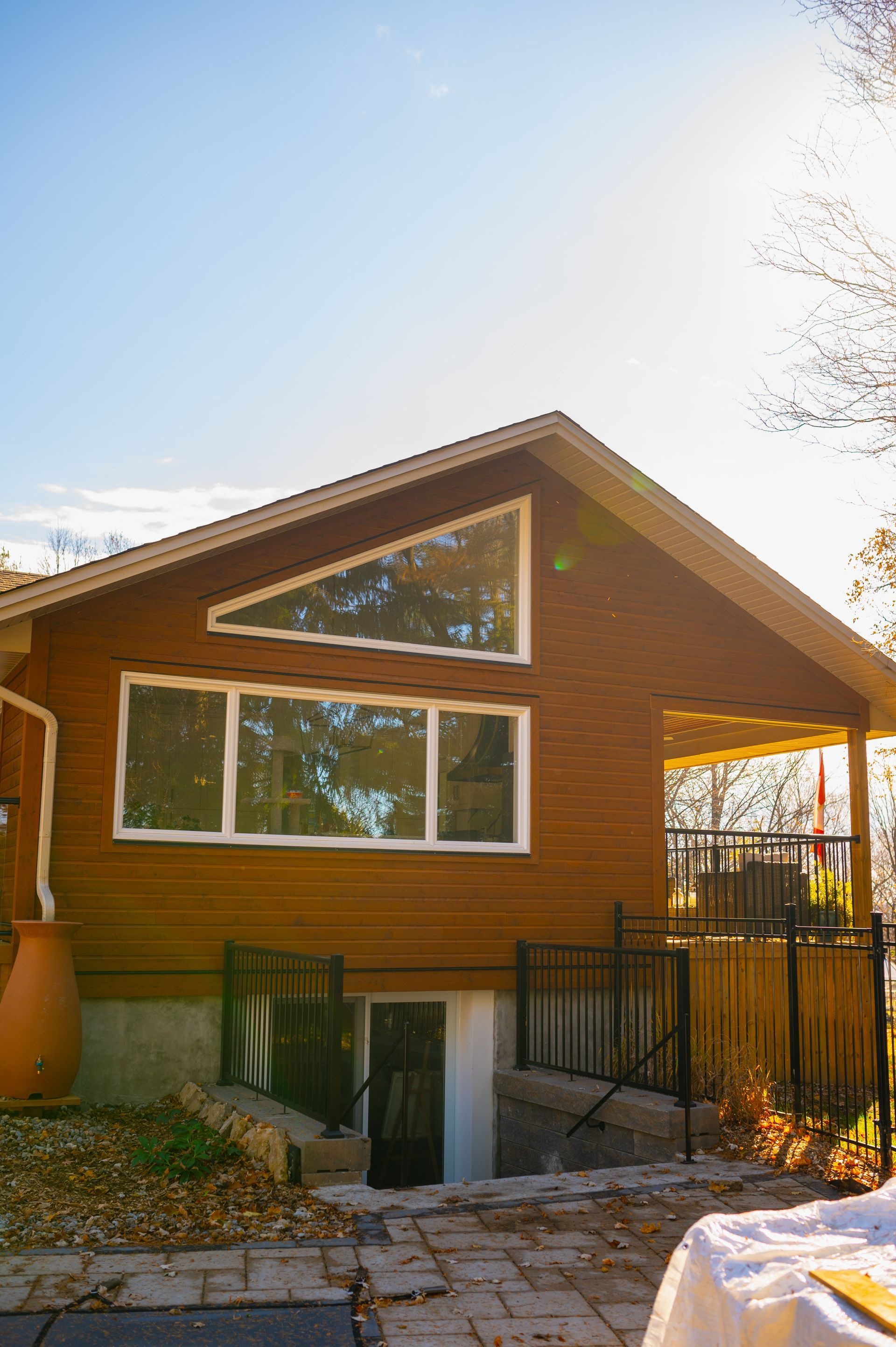 A wooden house with a lot of windows and a table in front of it.