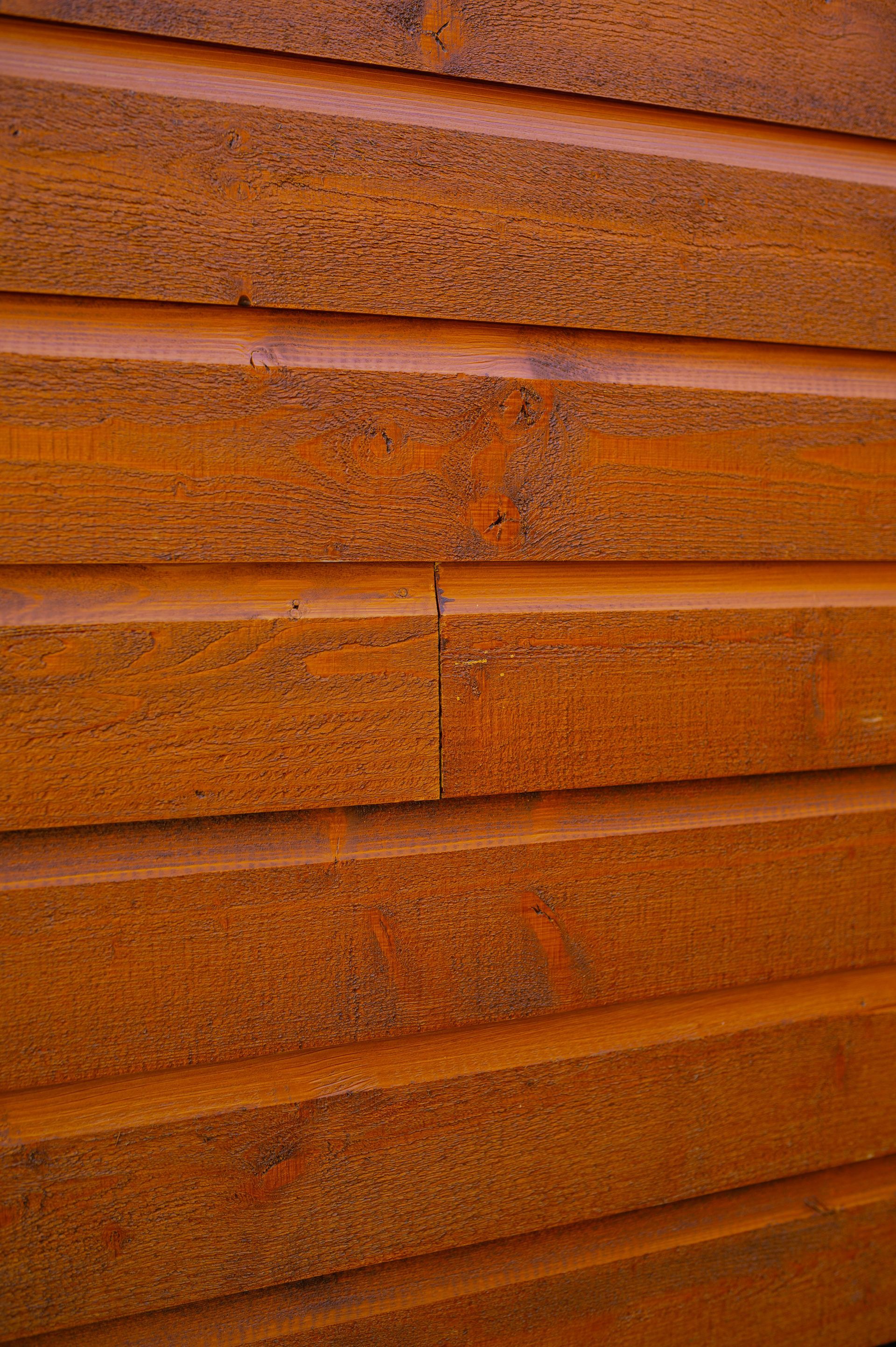 A close up of a wooden wall with a hole in it.