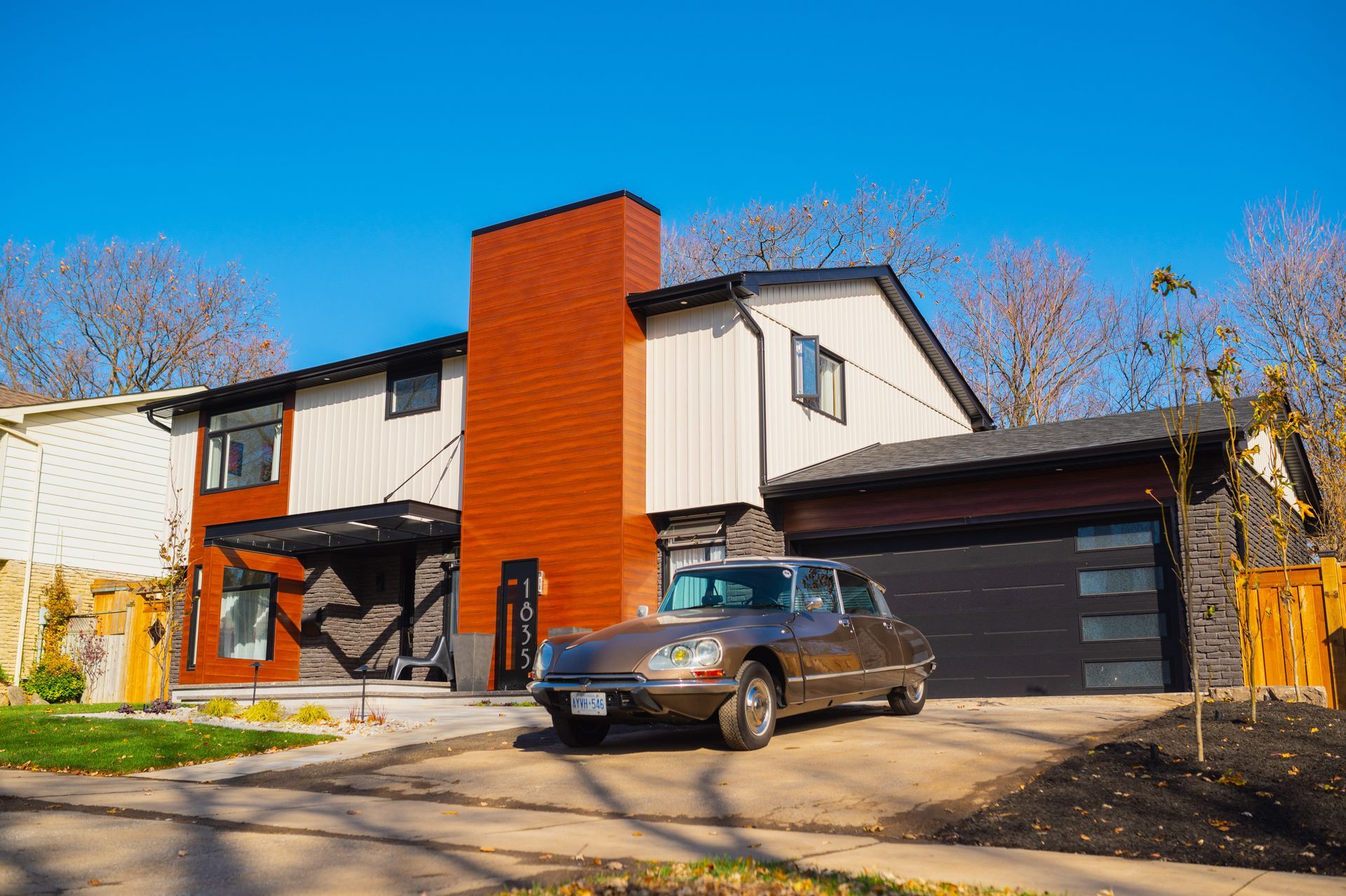 A car is parked in front of a large house.
