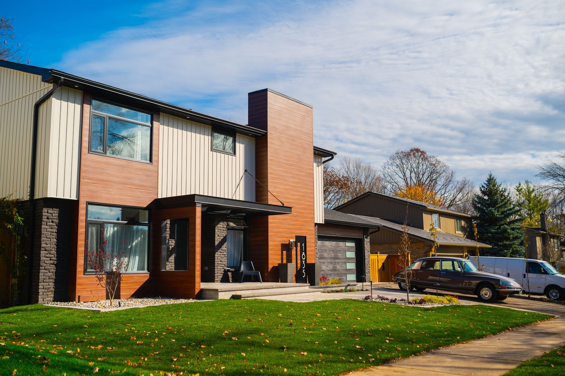 A large brick house with a car parked in front of it.