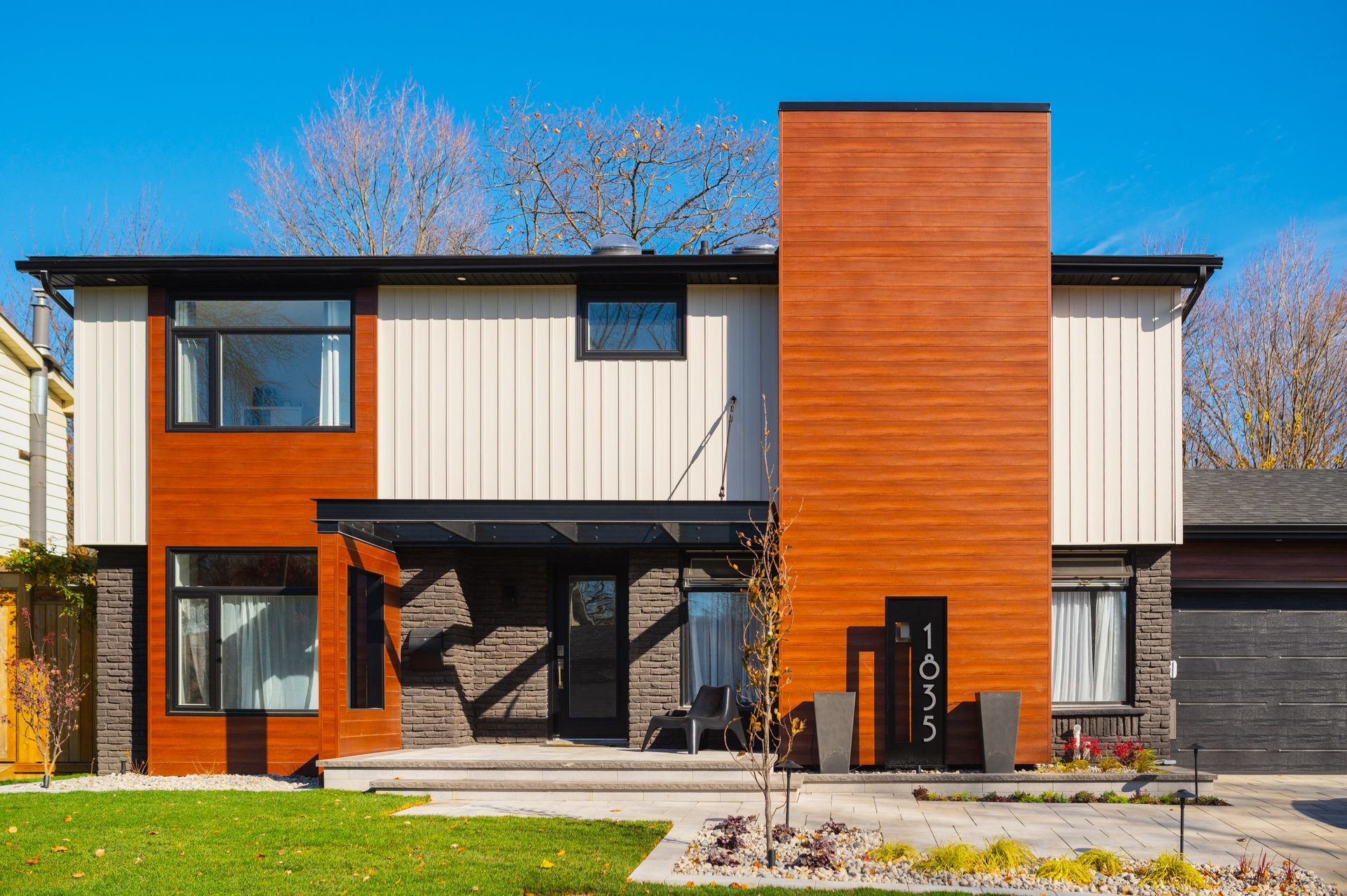 A large house with a lot of windows and a large lawn in front of it.