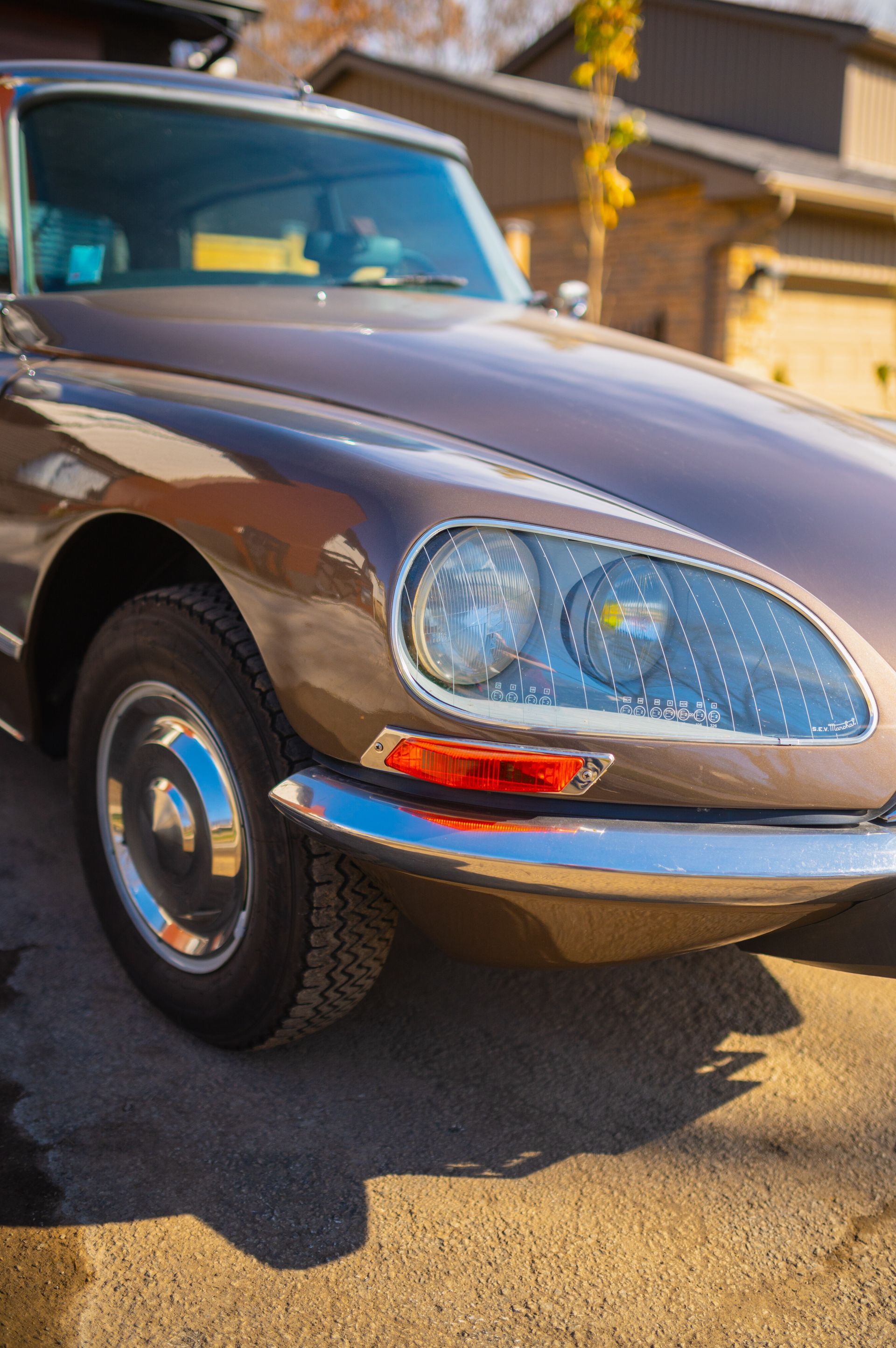 A close up of an old car parked in front of a house.