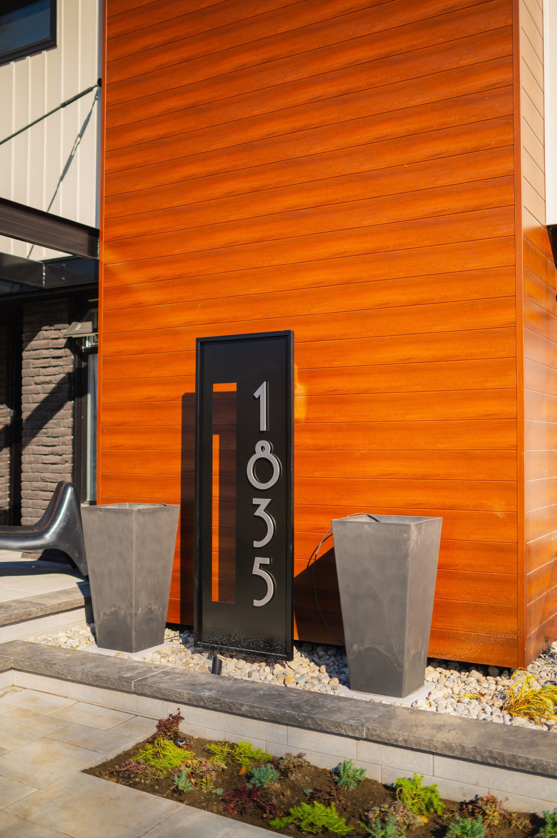 A wooden building with a black sign on the side of it.