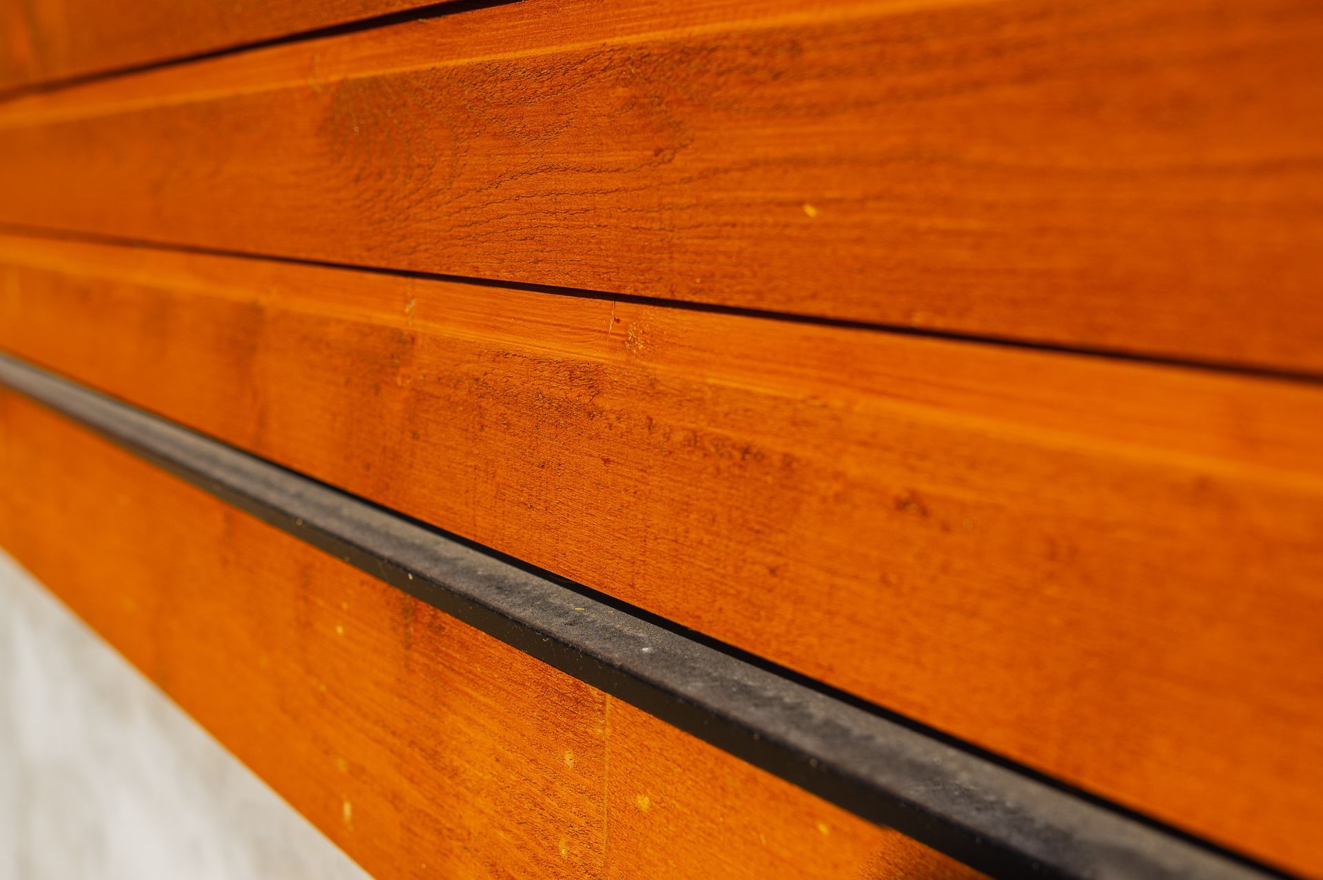 A close up of a wooden wall with a metal railing.
