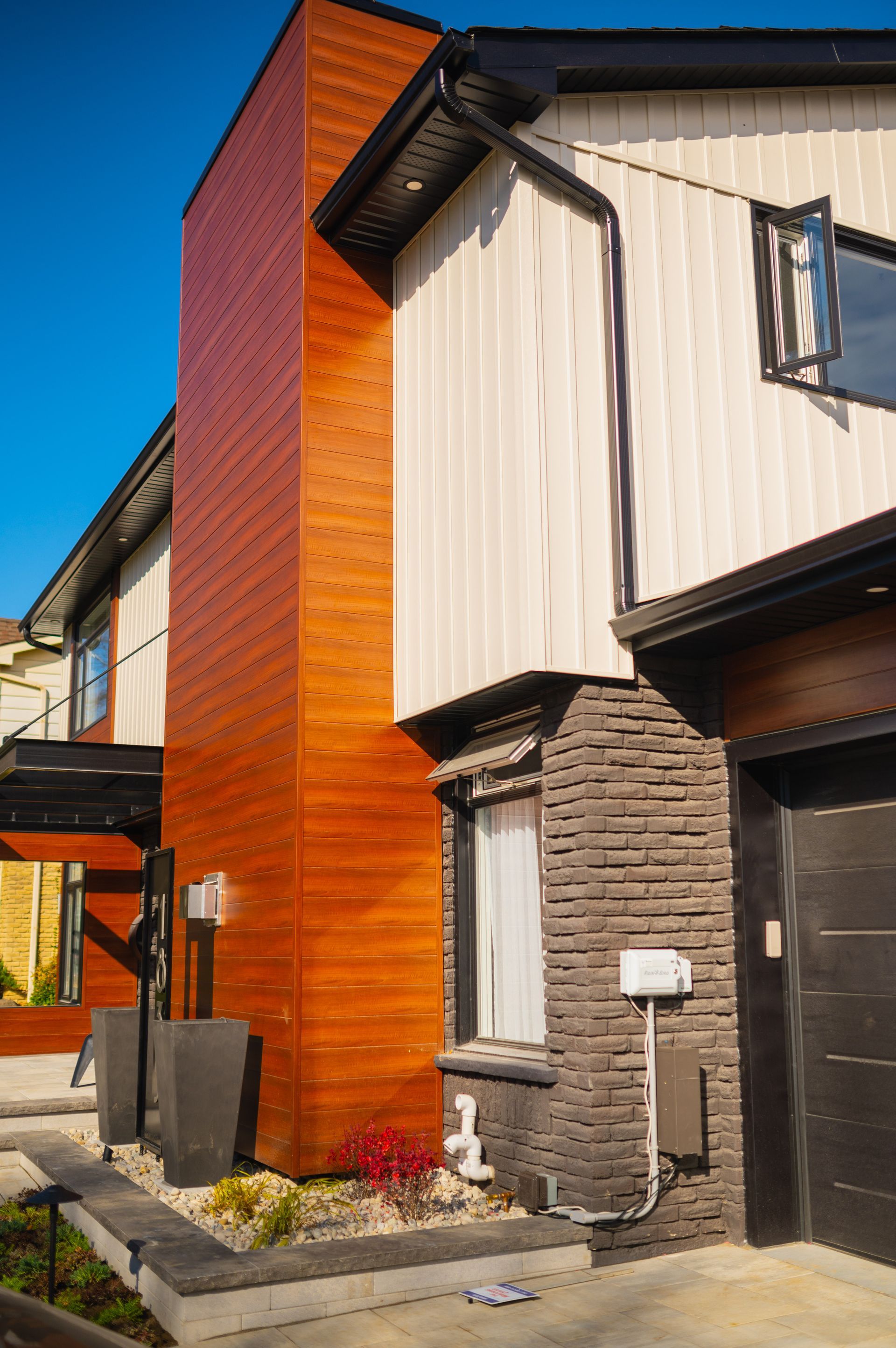 A house with a wooden siding and a black garage door