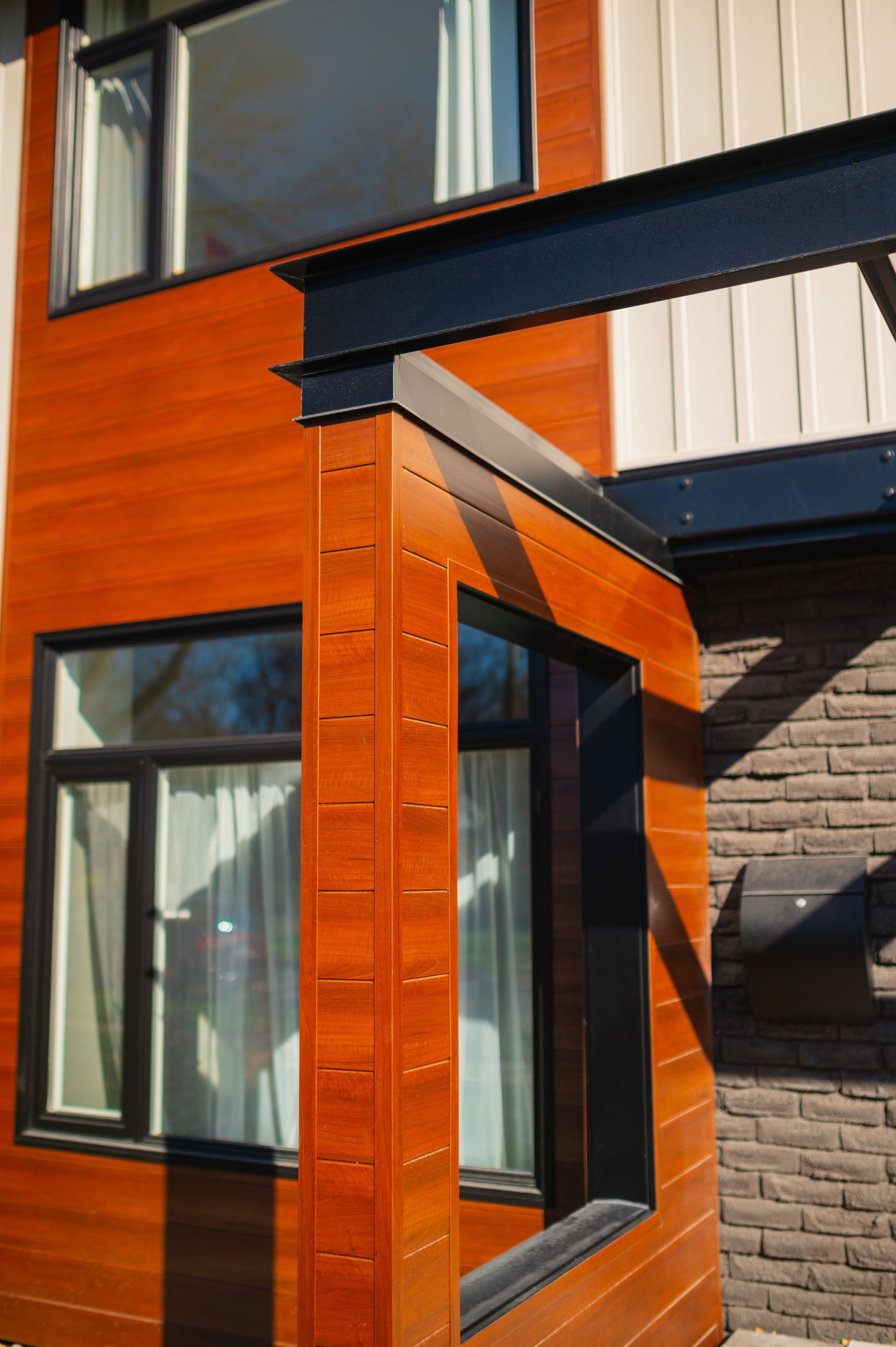 A house with a wooden siding and black windows