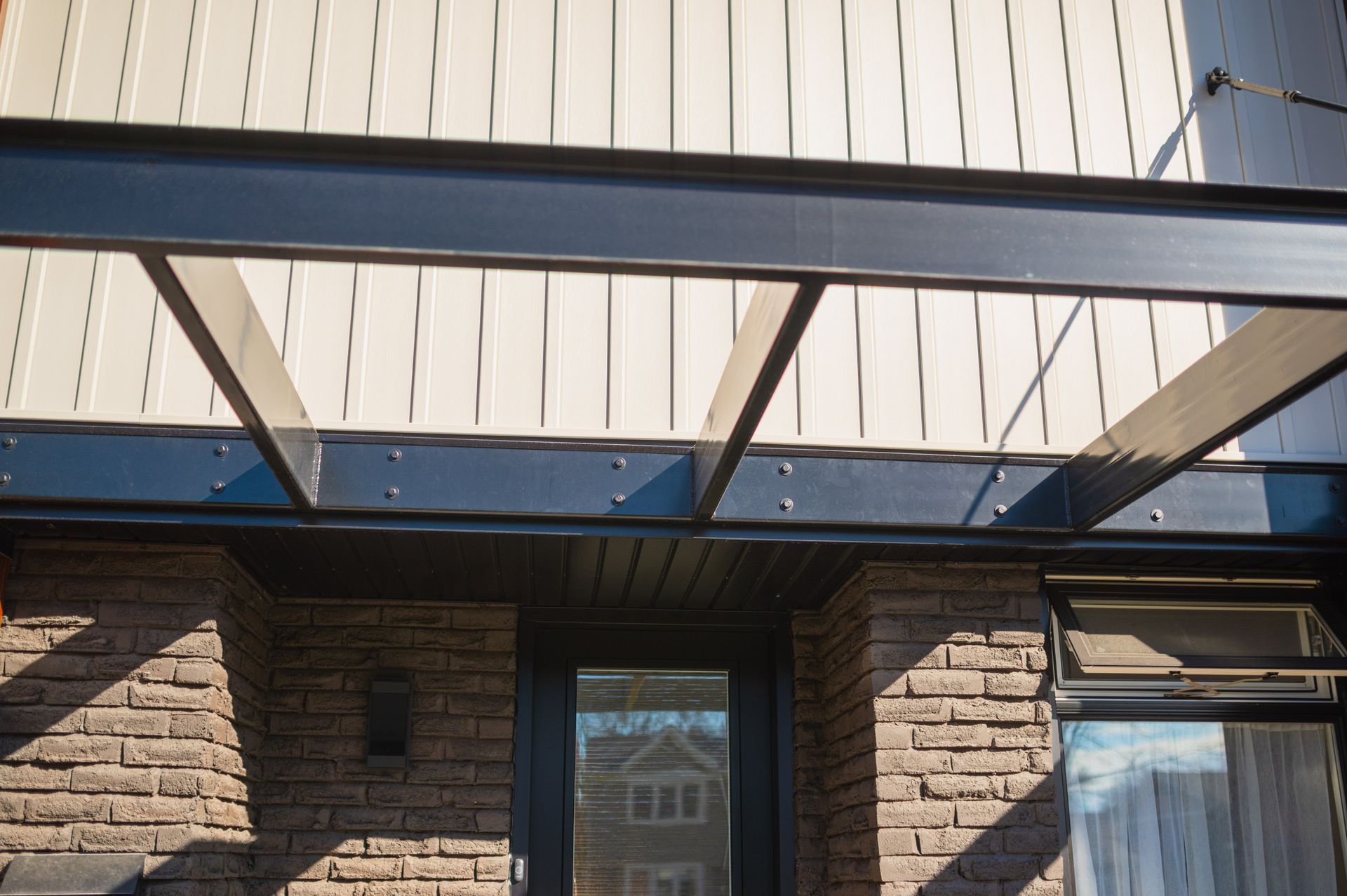 A brick building with a metal roof and a glass door.