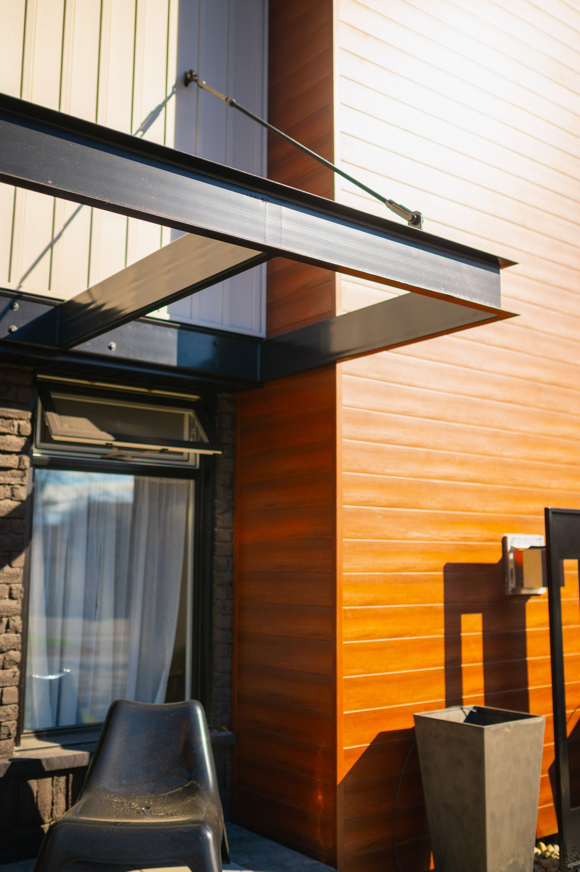 A chair sits under a canopy on the side of a building