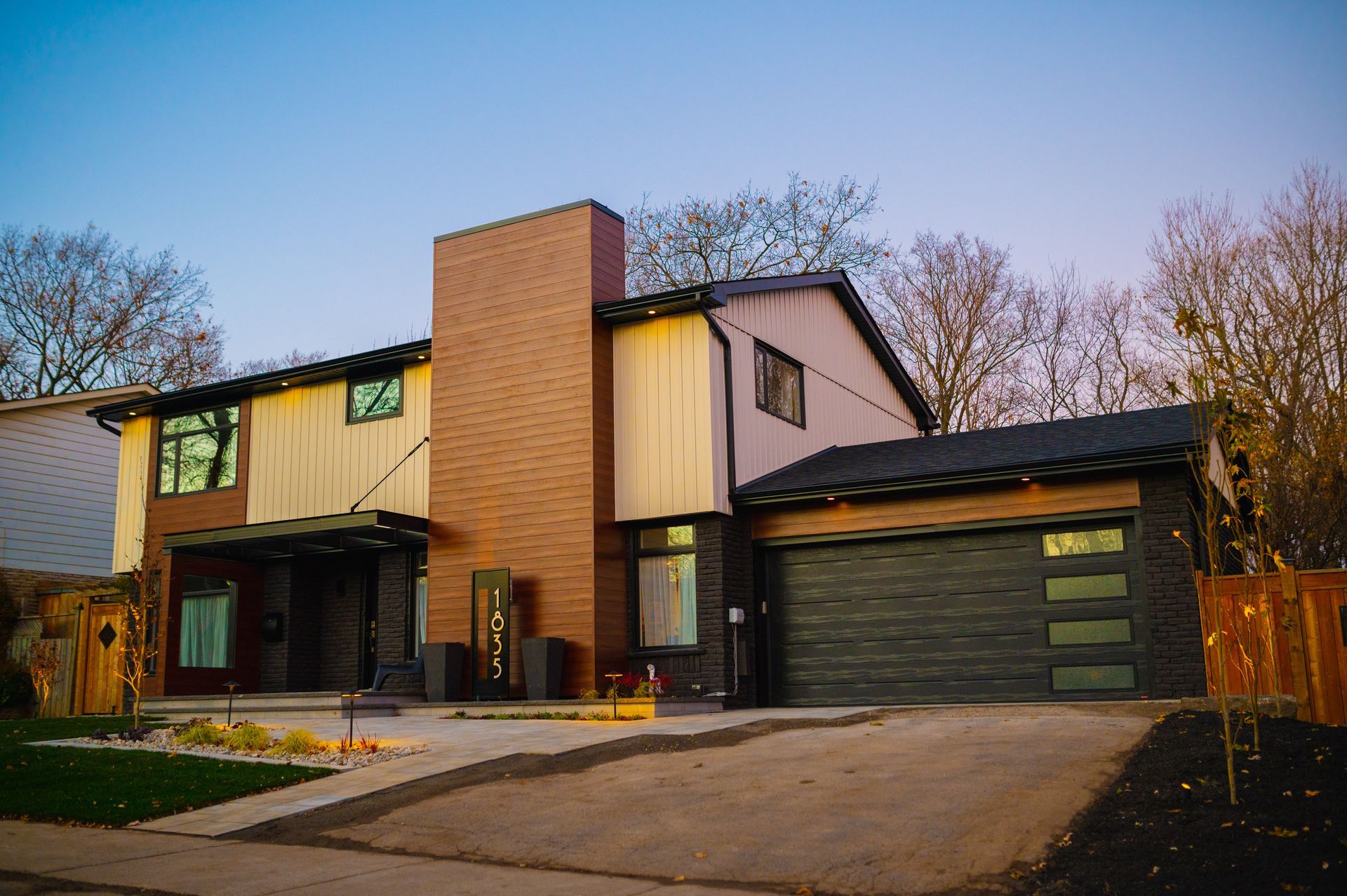 A large house with two garages and a driveway in front of it.