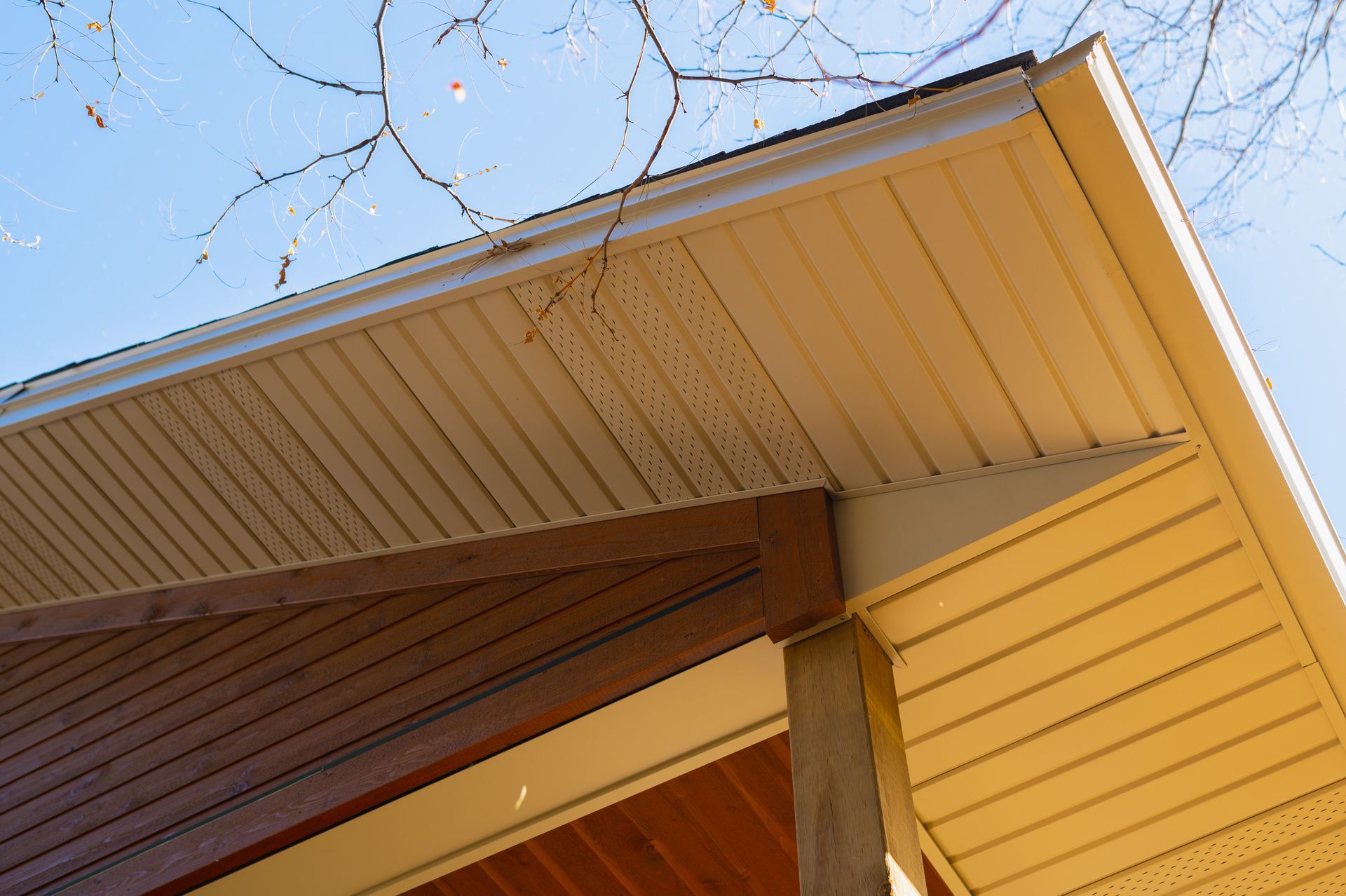 A close up of the roof of a house with a blue sky in the background.