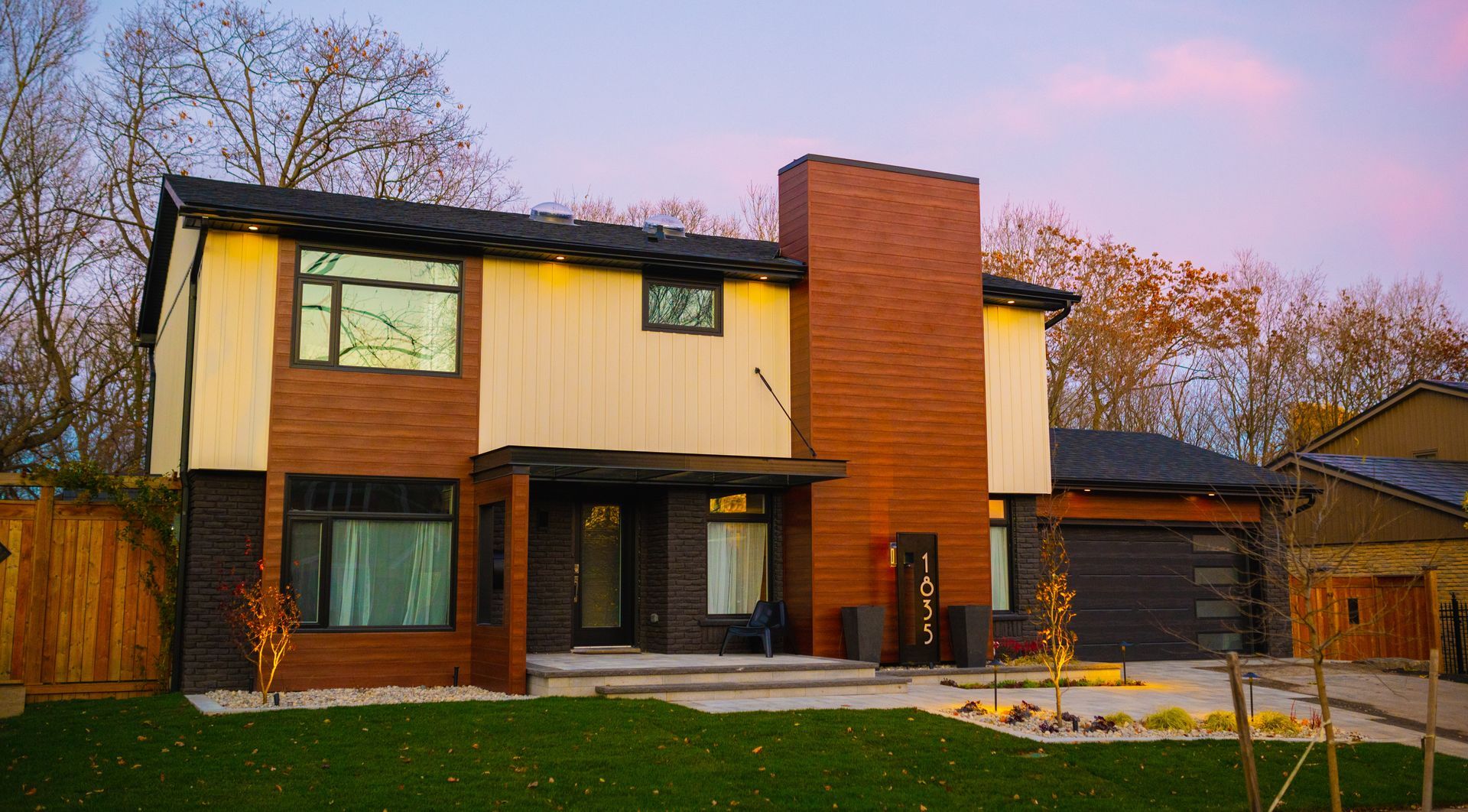 A large house with a lot of windows and a brick chimney.