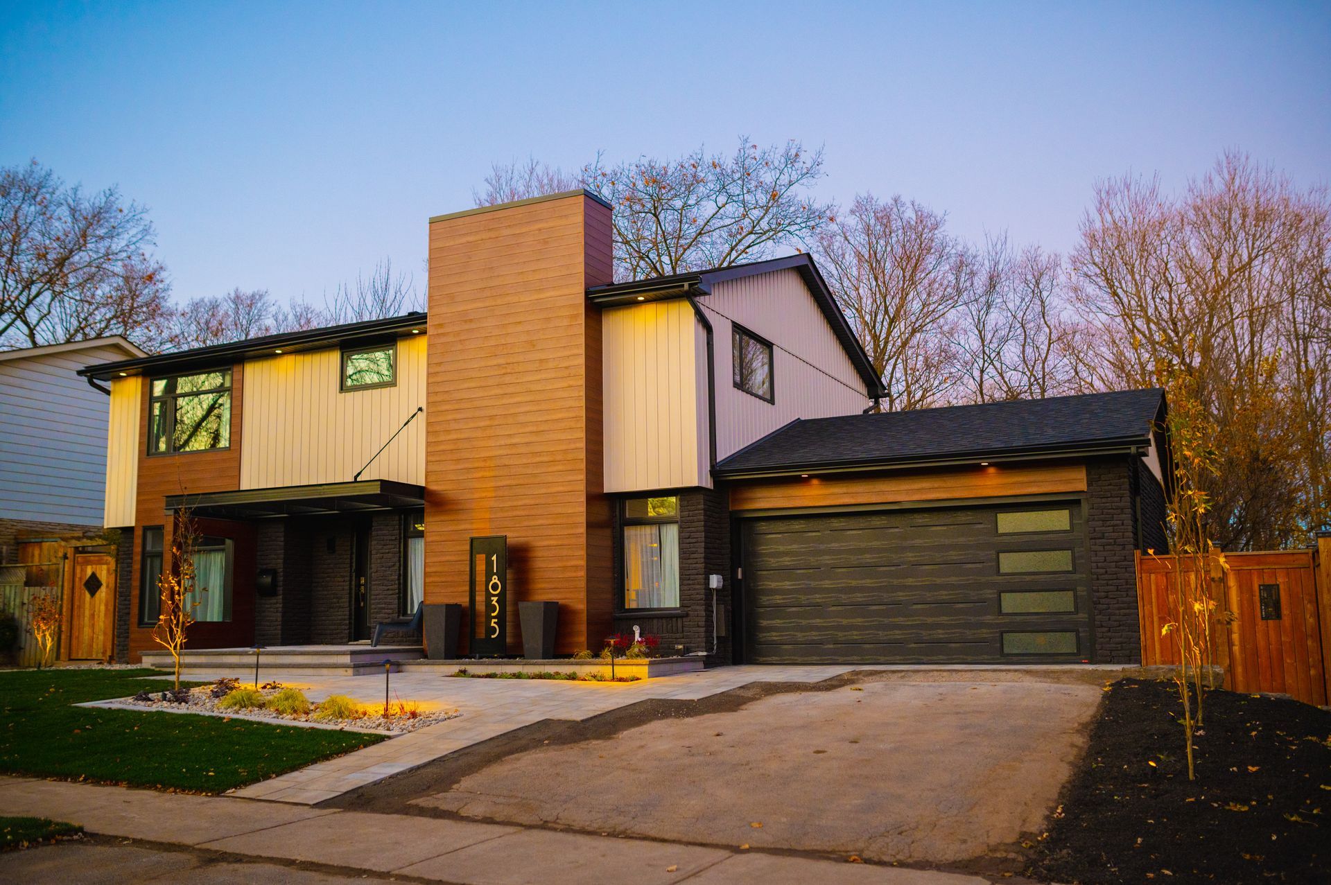 A large brick house with a garage and a driveway in front of it.