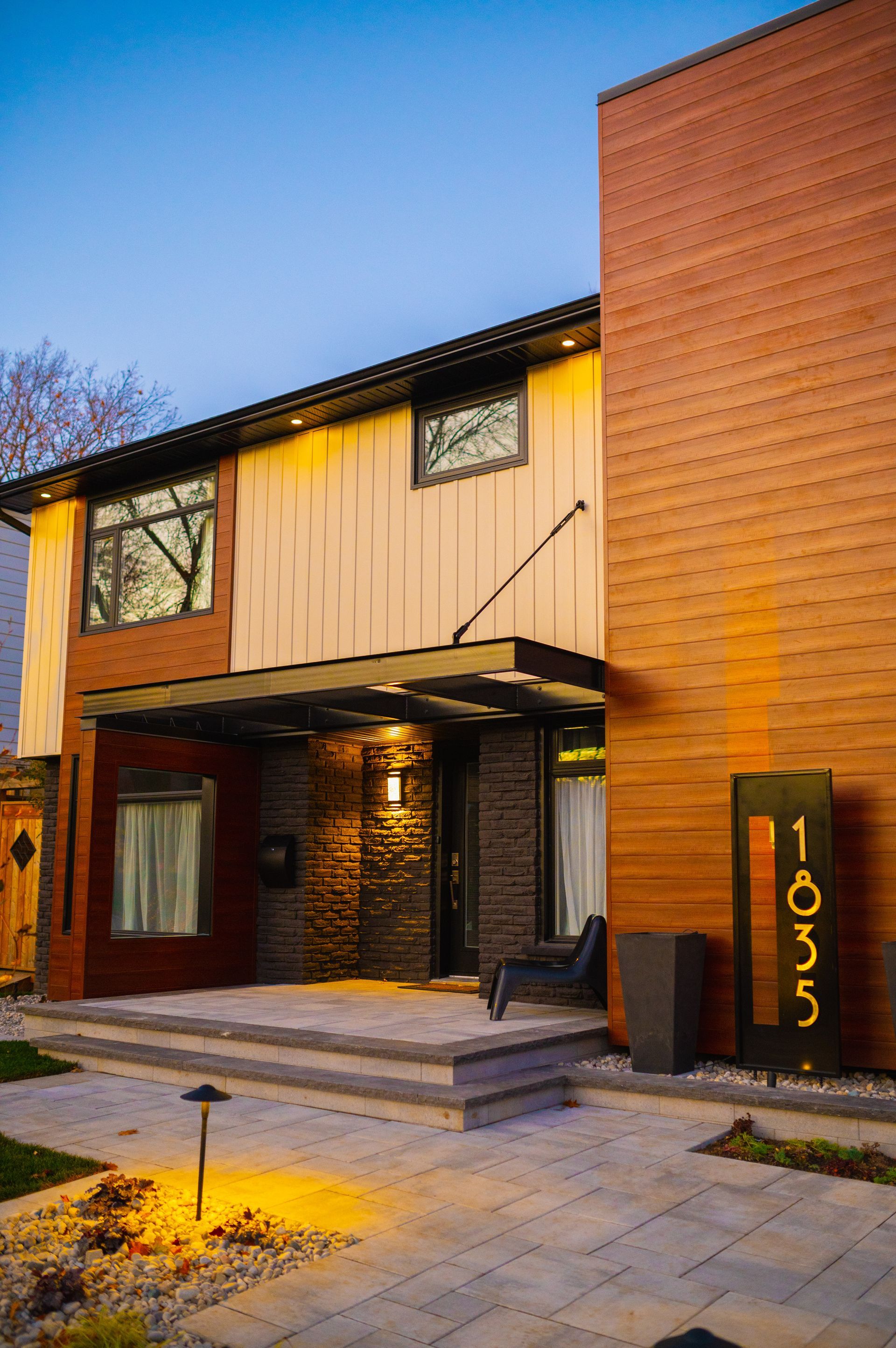 A large house with a lot of windows and stairs is lit up at night.