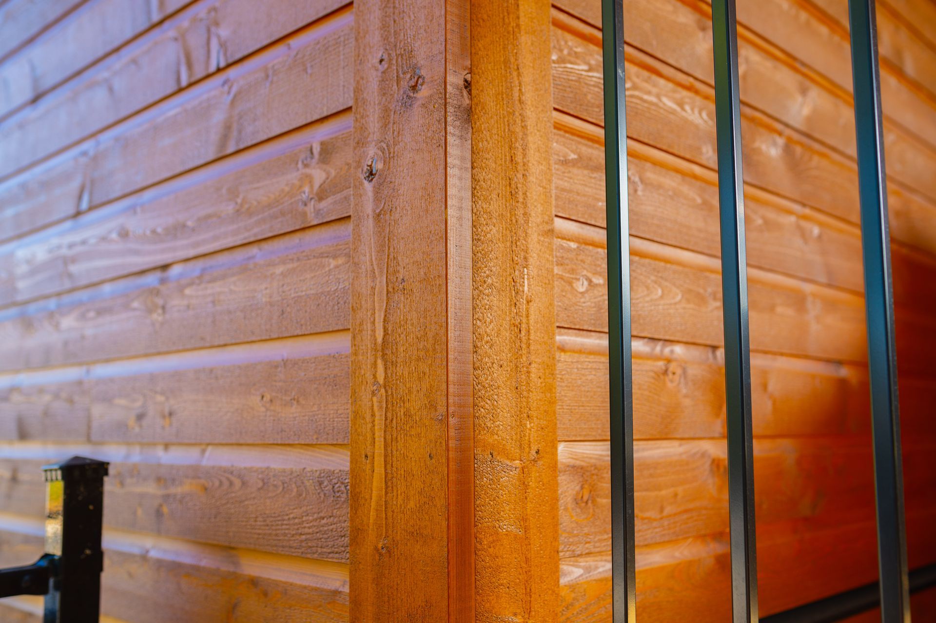 A close up of a wooden wall with a metal railing.