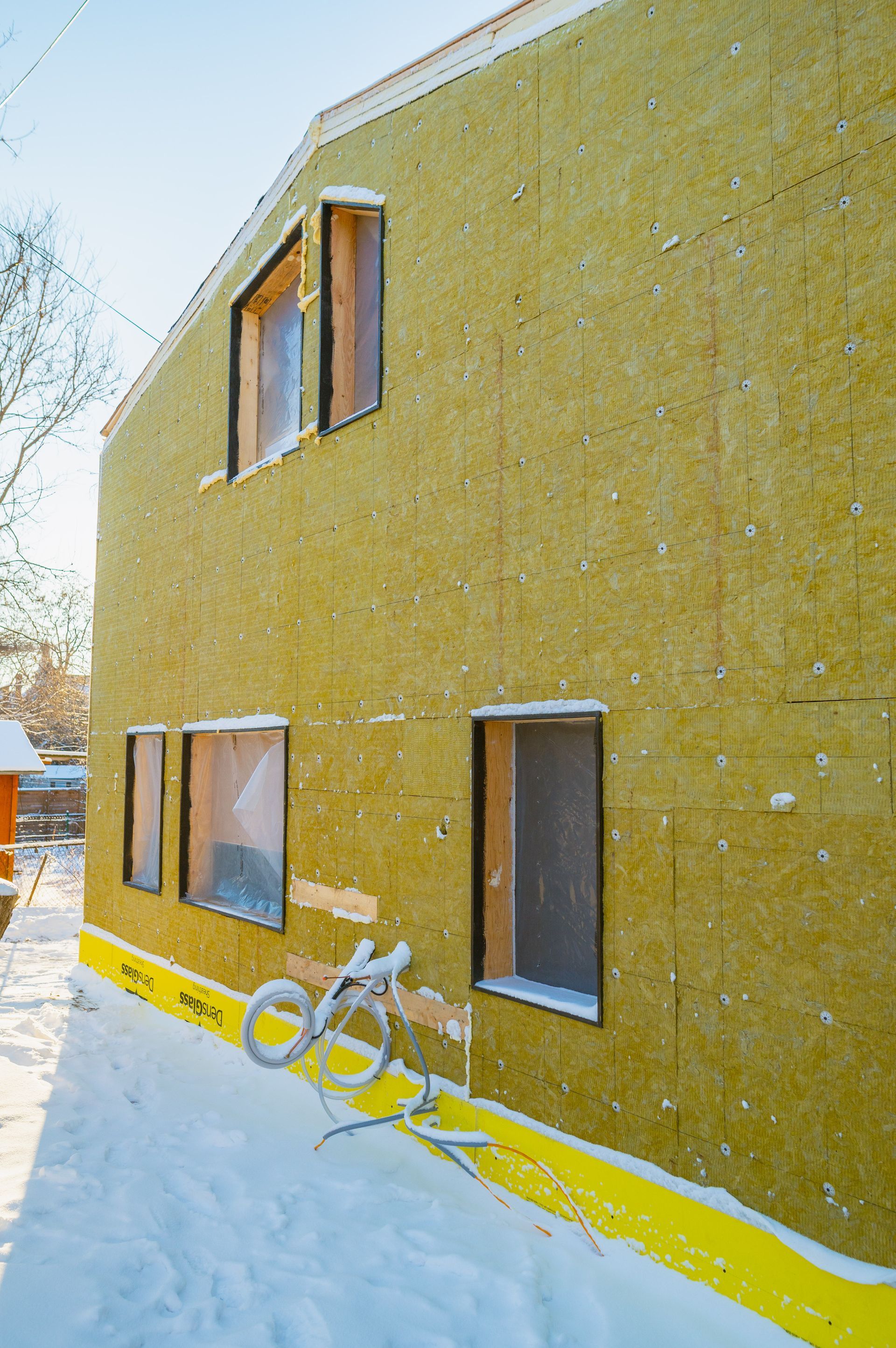 A house is being built with a lot of insulation on the side of it.