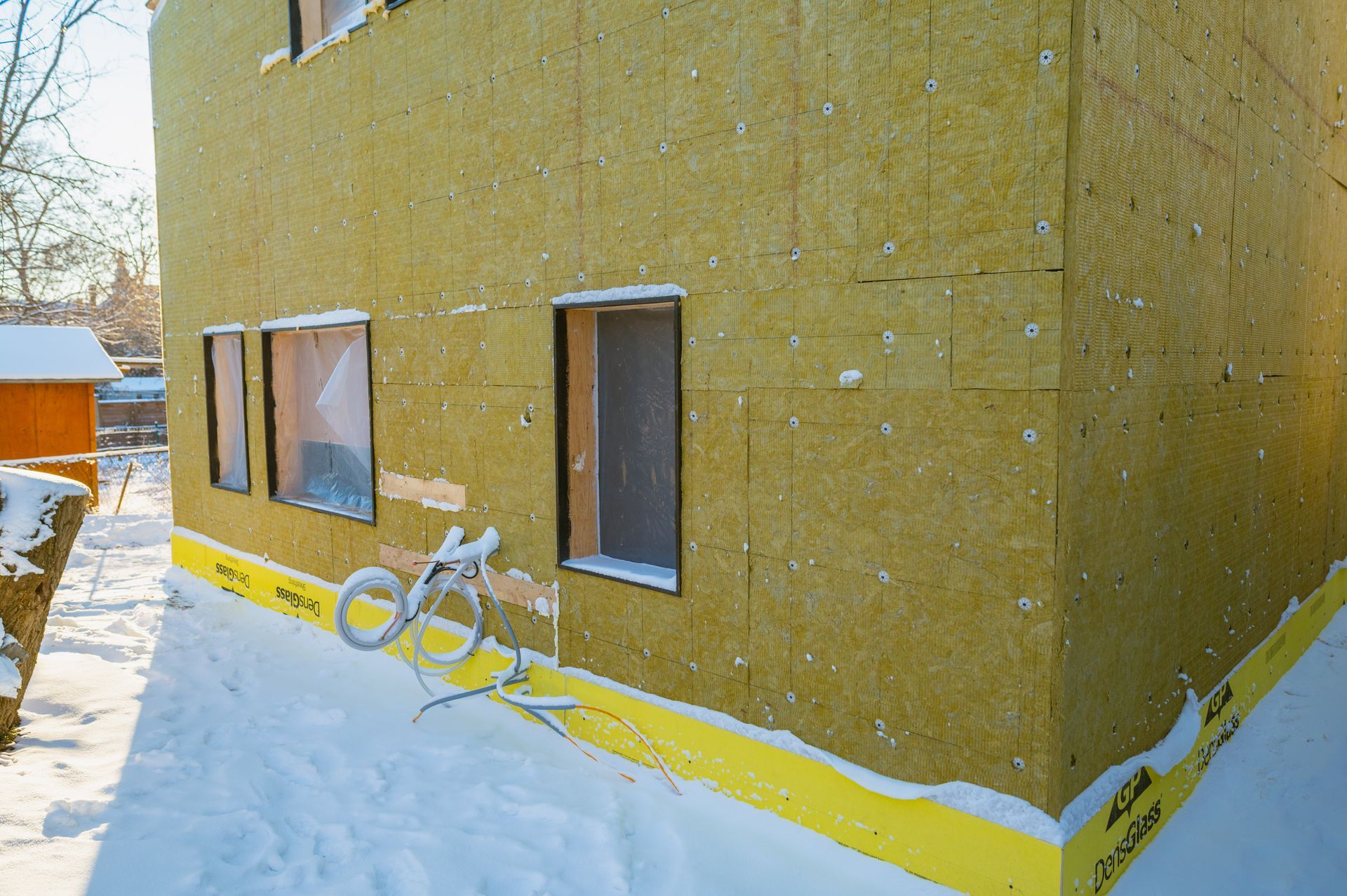 A house is being built in the snow with a lot of snow on the ground.