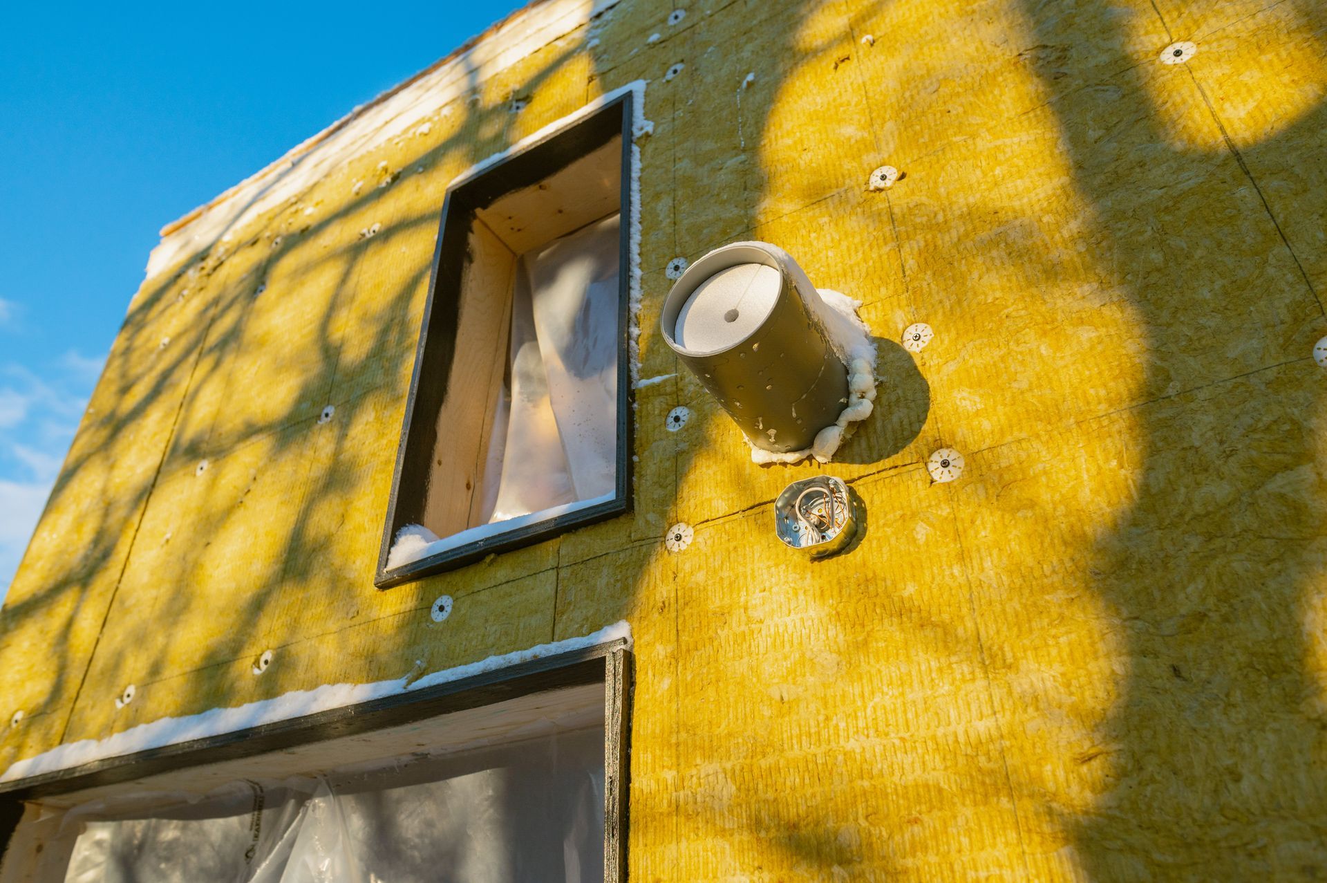 A yellow wall with a window and a light on it.