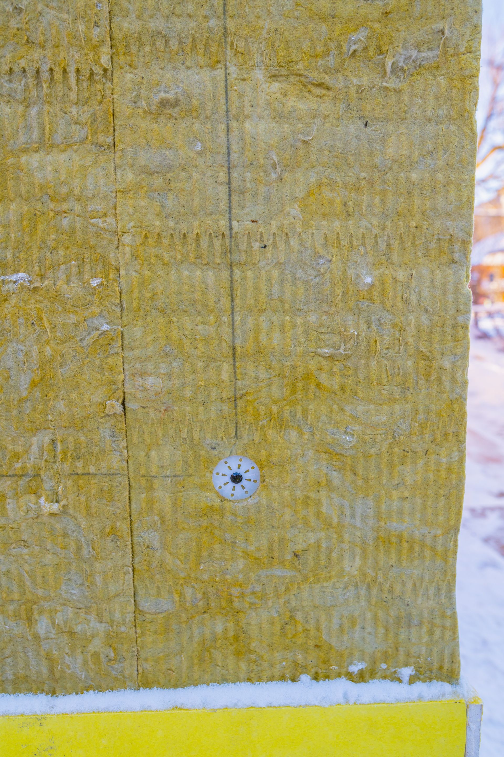 A close up of a wall with a screw in it.