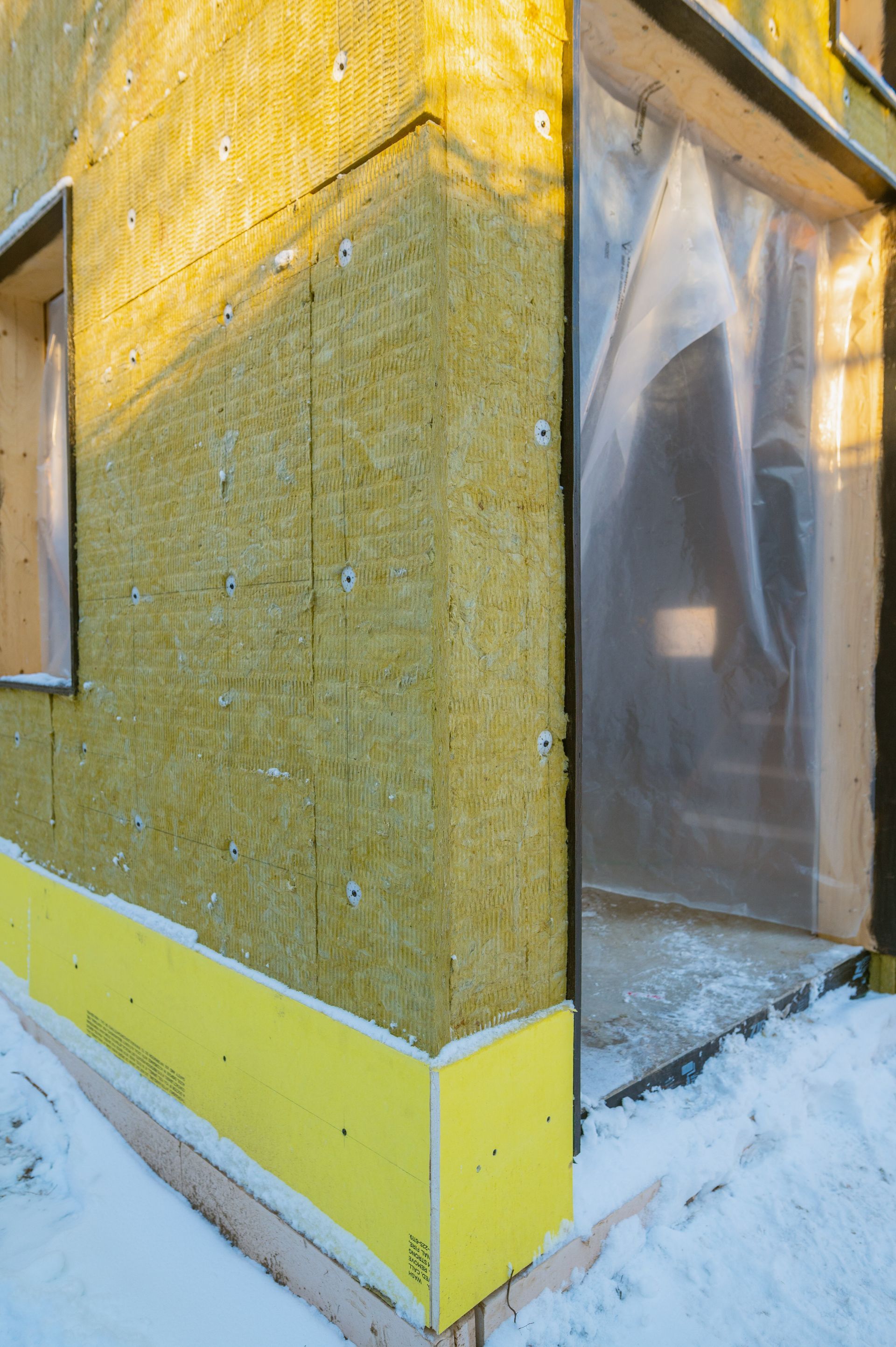 A house is being built with a lot of insulation on the side of it.