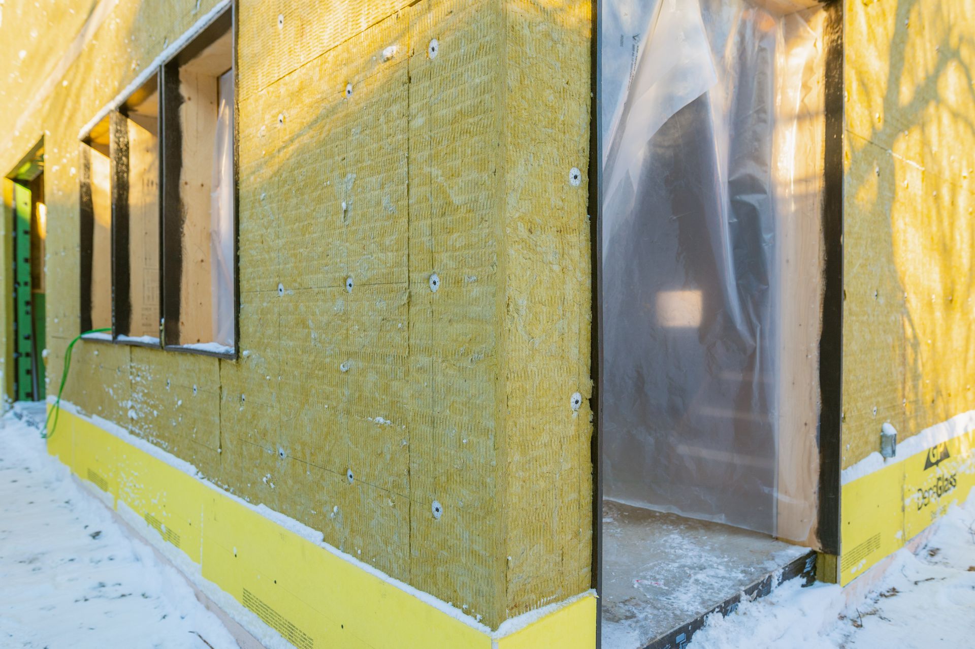 A building under construction with a lot of insulation on the side of it.