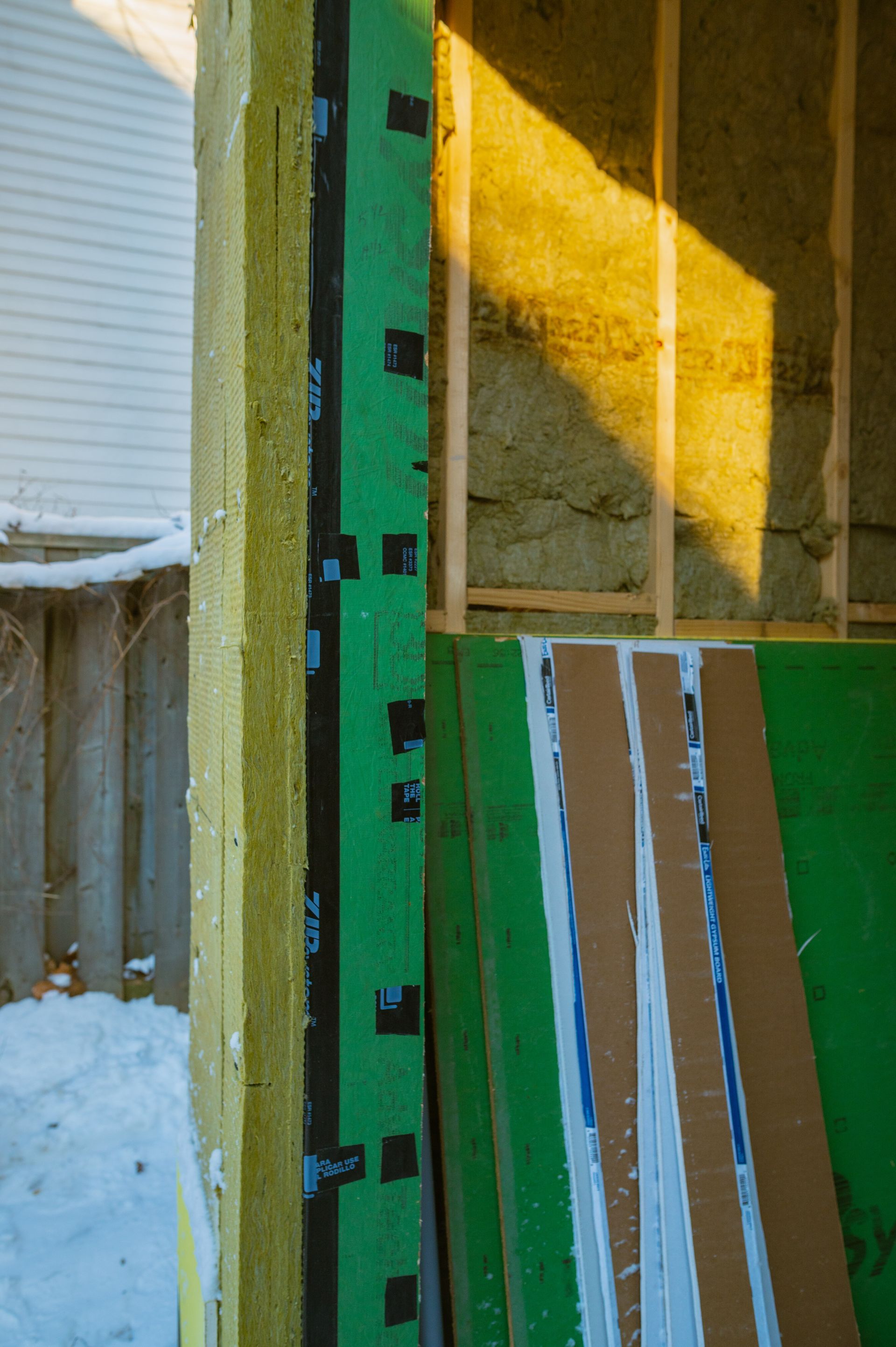 A green wall with a lot of pieces of wood on it