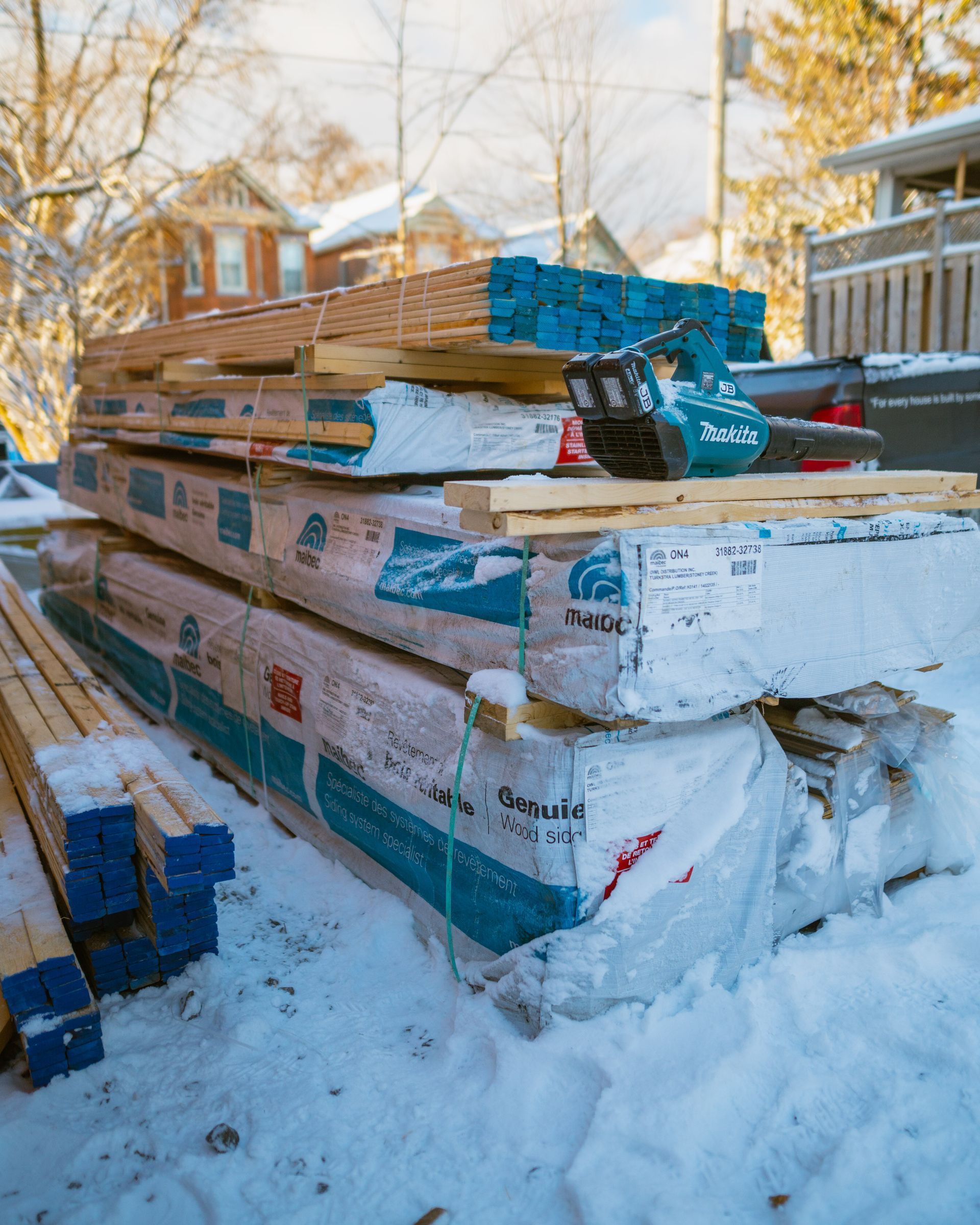 A pile of wood is stacked on top of each other in the snow.