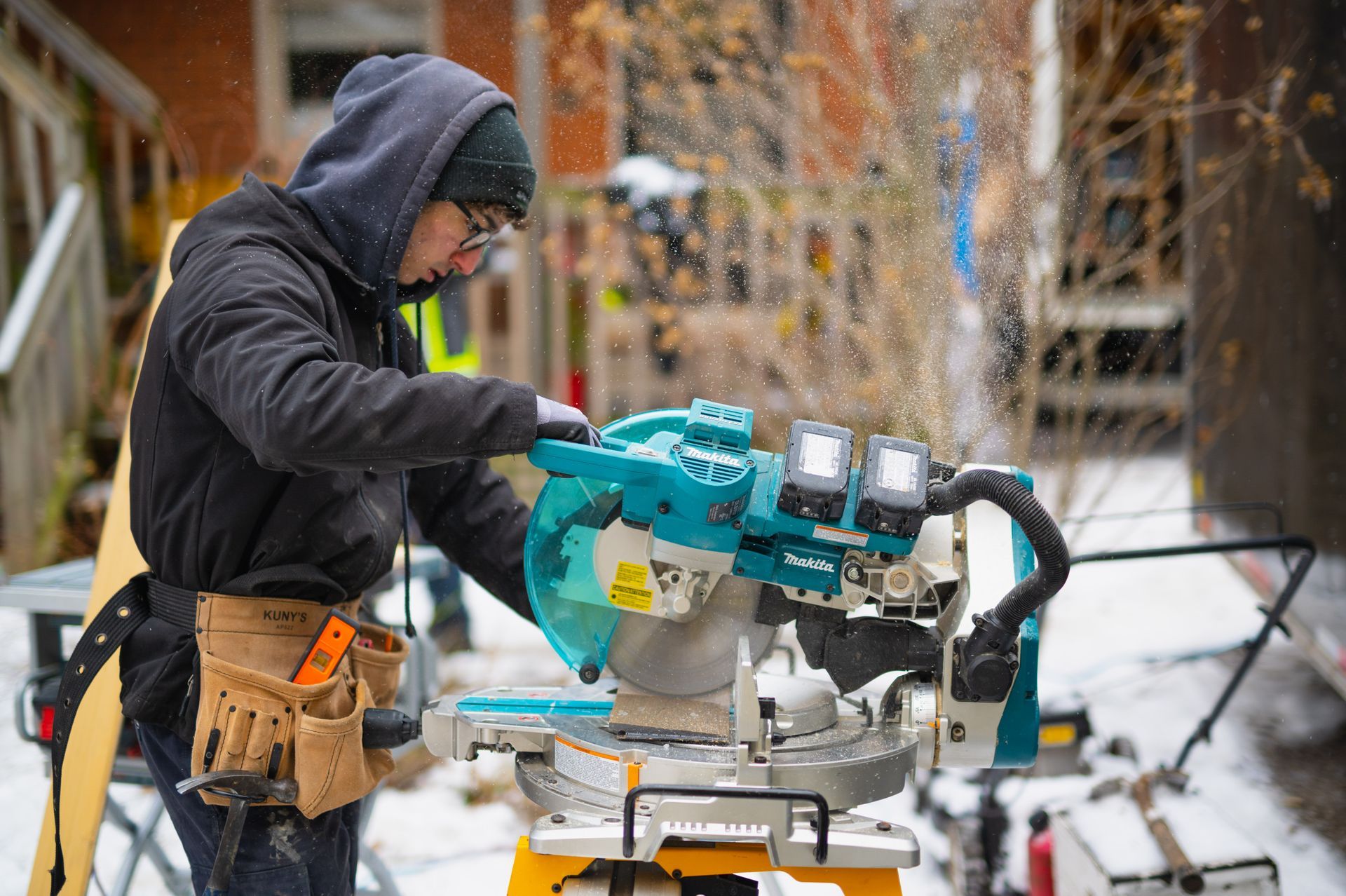 A man is cutting a piece of wood with a circular saw.