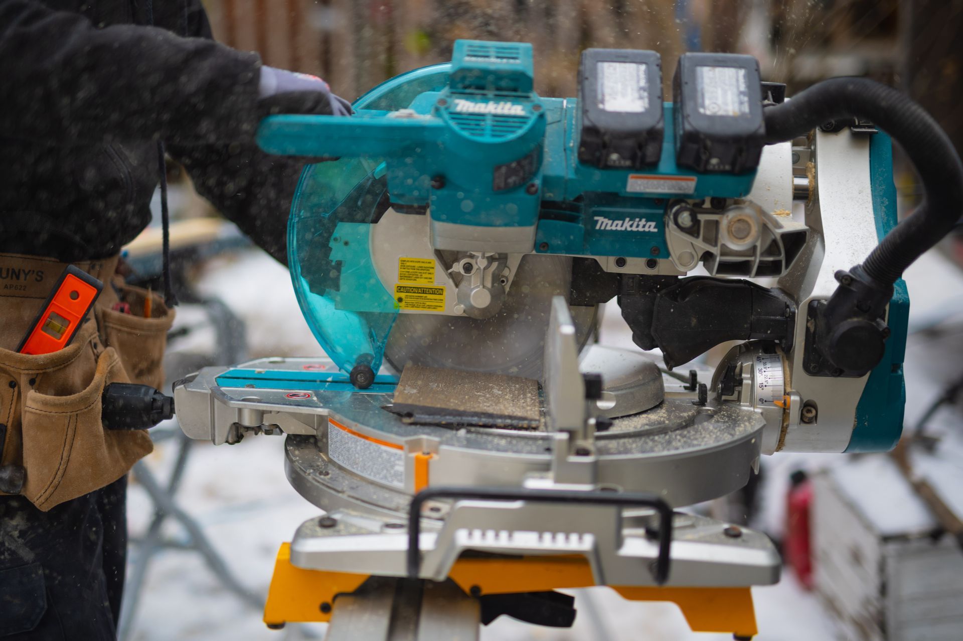 A man is using a circular saw to cut a piece of wood.