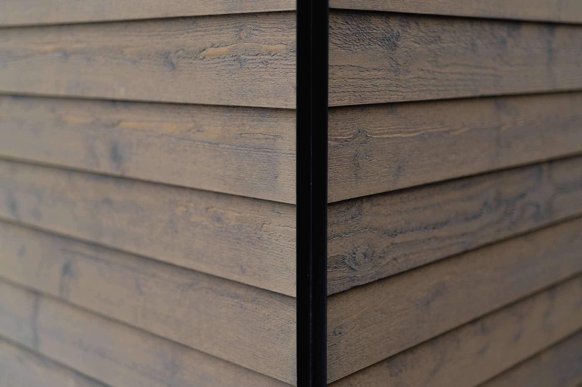 A close up of a wooden siding on a building.