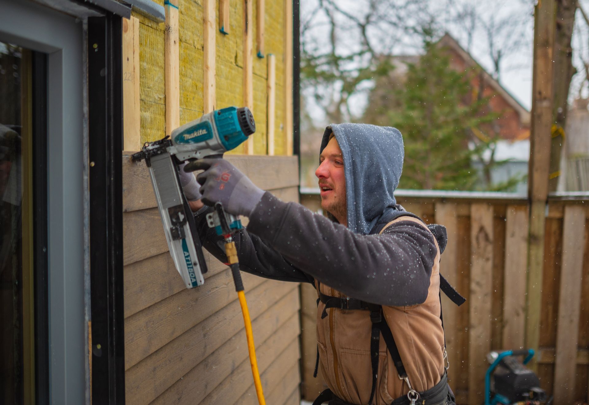 man piercing the outside wall of a house