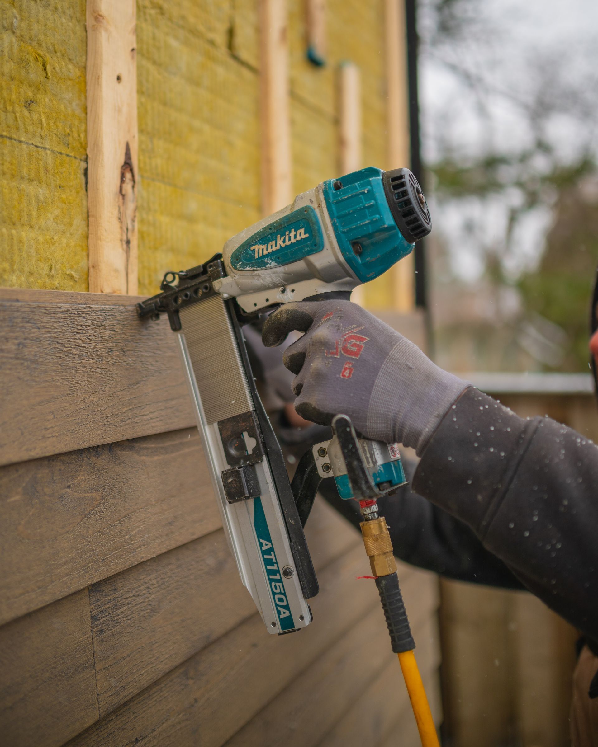 man piercing the outside wall of a house