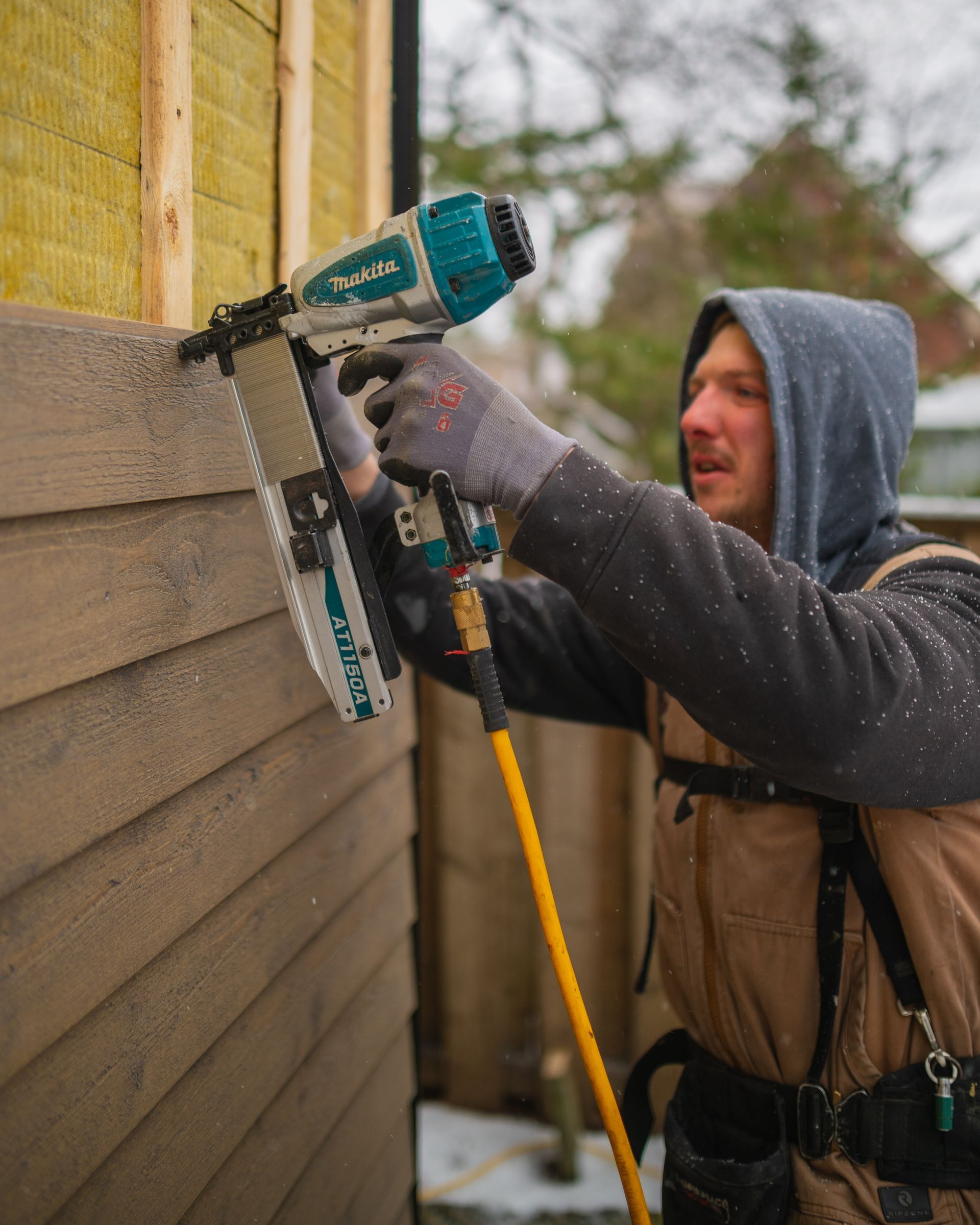 man installing siding on a house