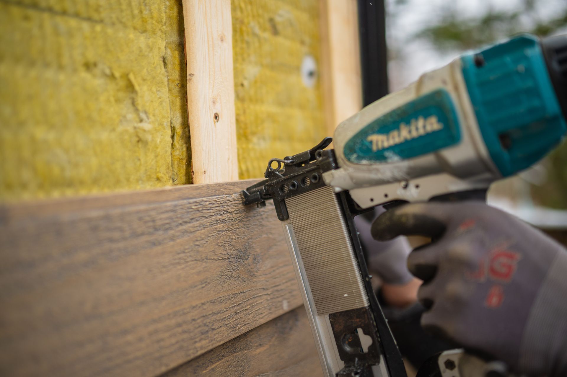man installing siding on a house