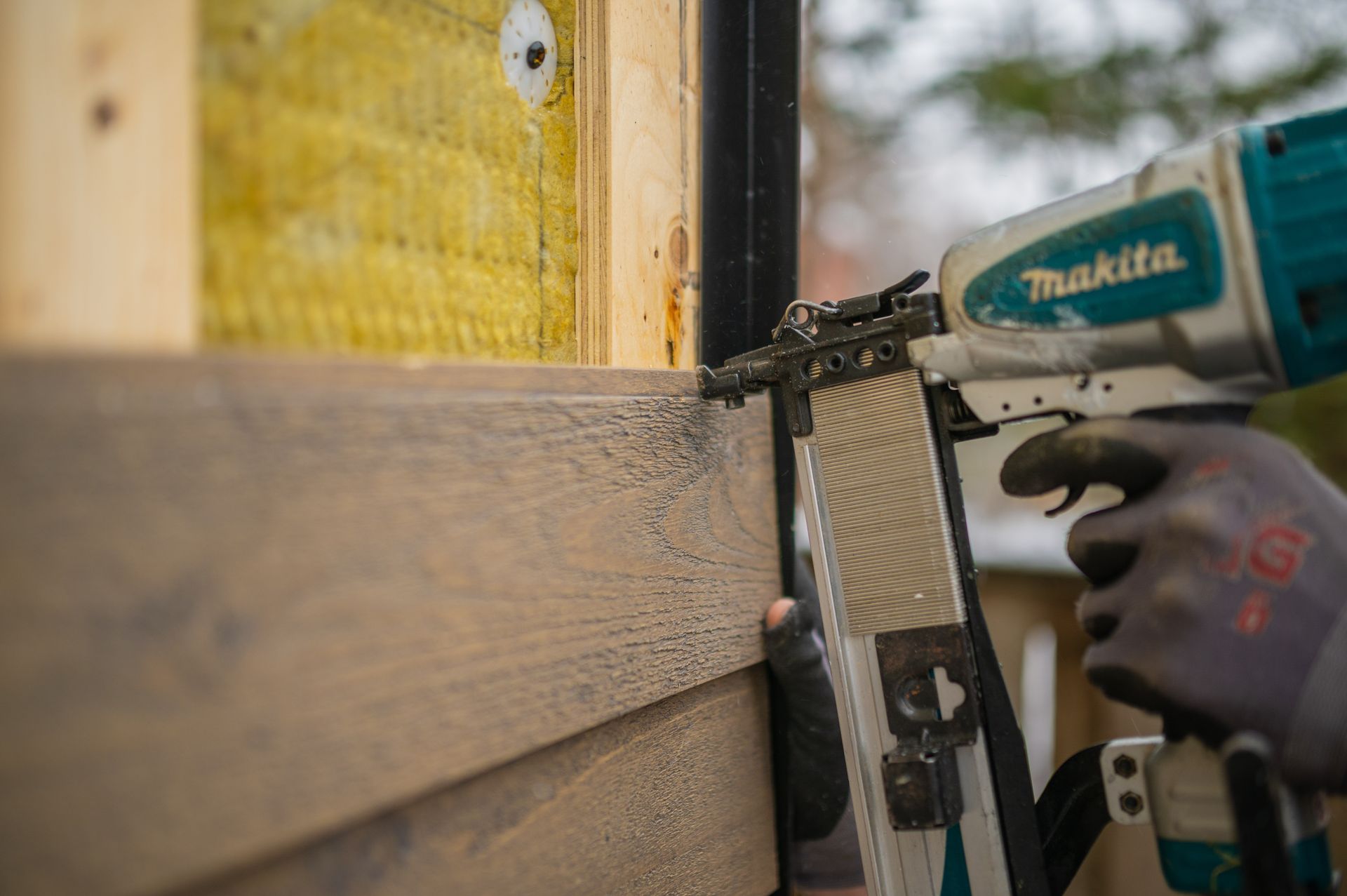 man installing siding on a house