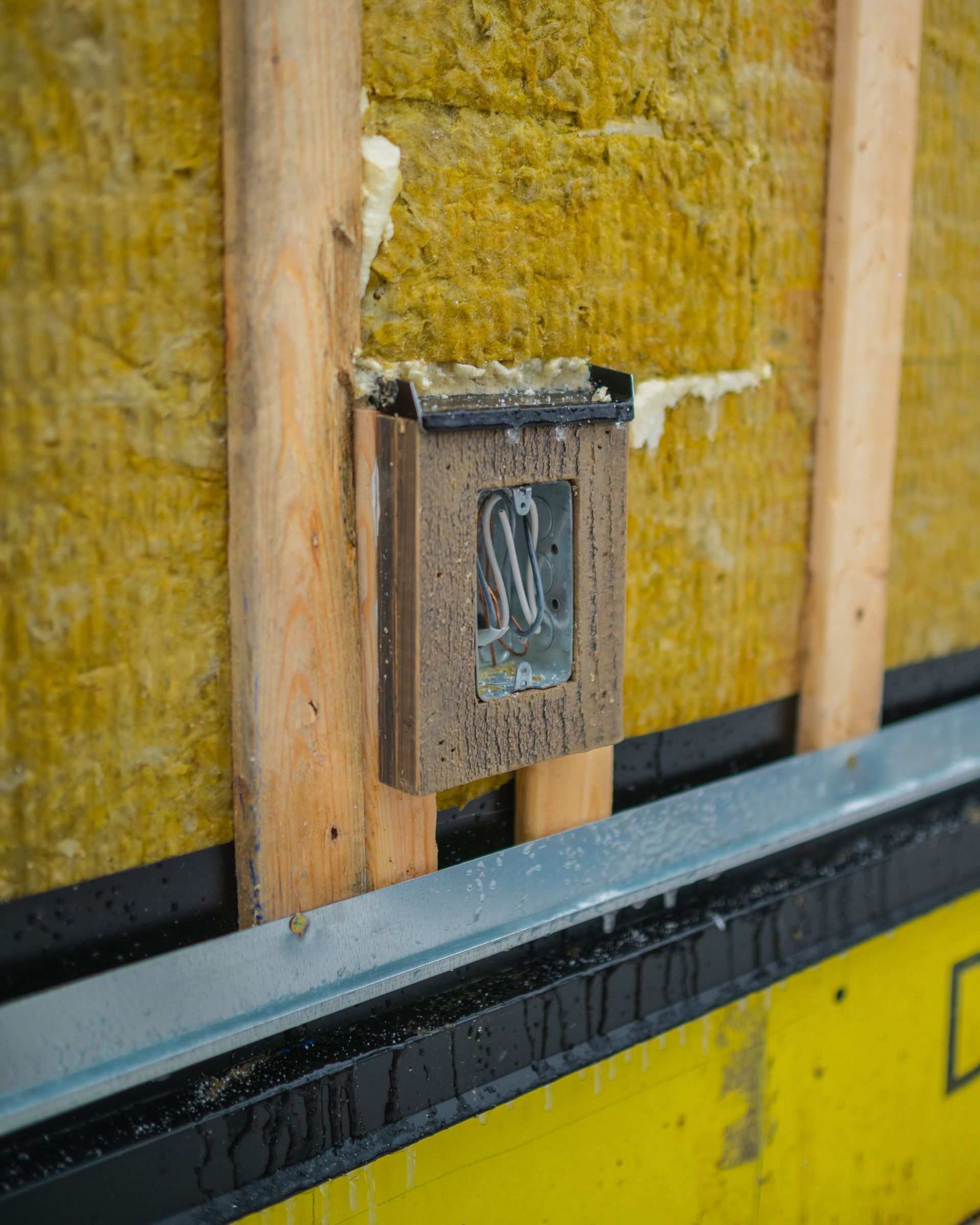 A wooden box with the letter s on it is attached to a wall.