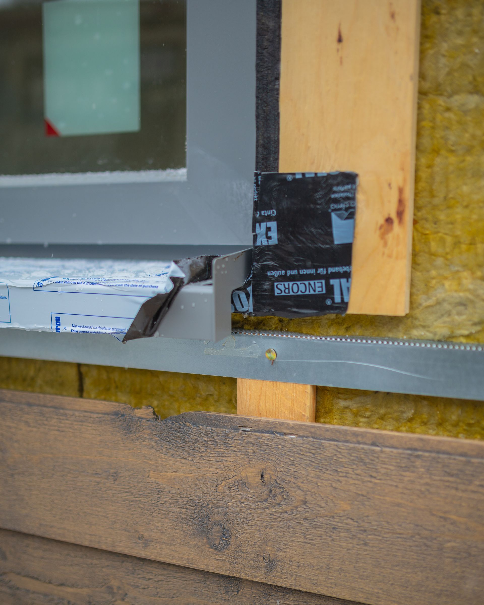 A window is being installed on a wooden wall.