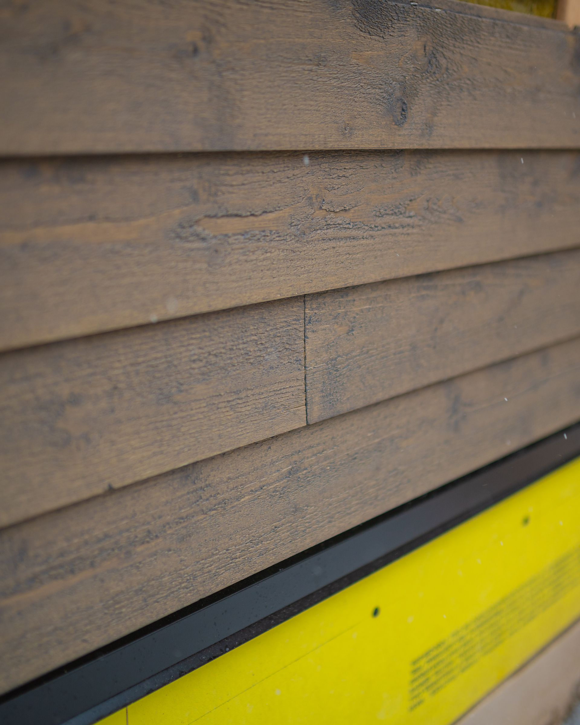 A close up of a wooden wall with a yellow border.