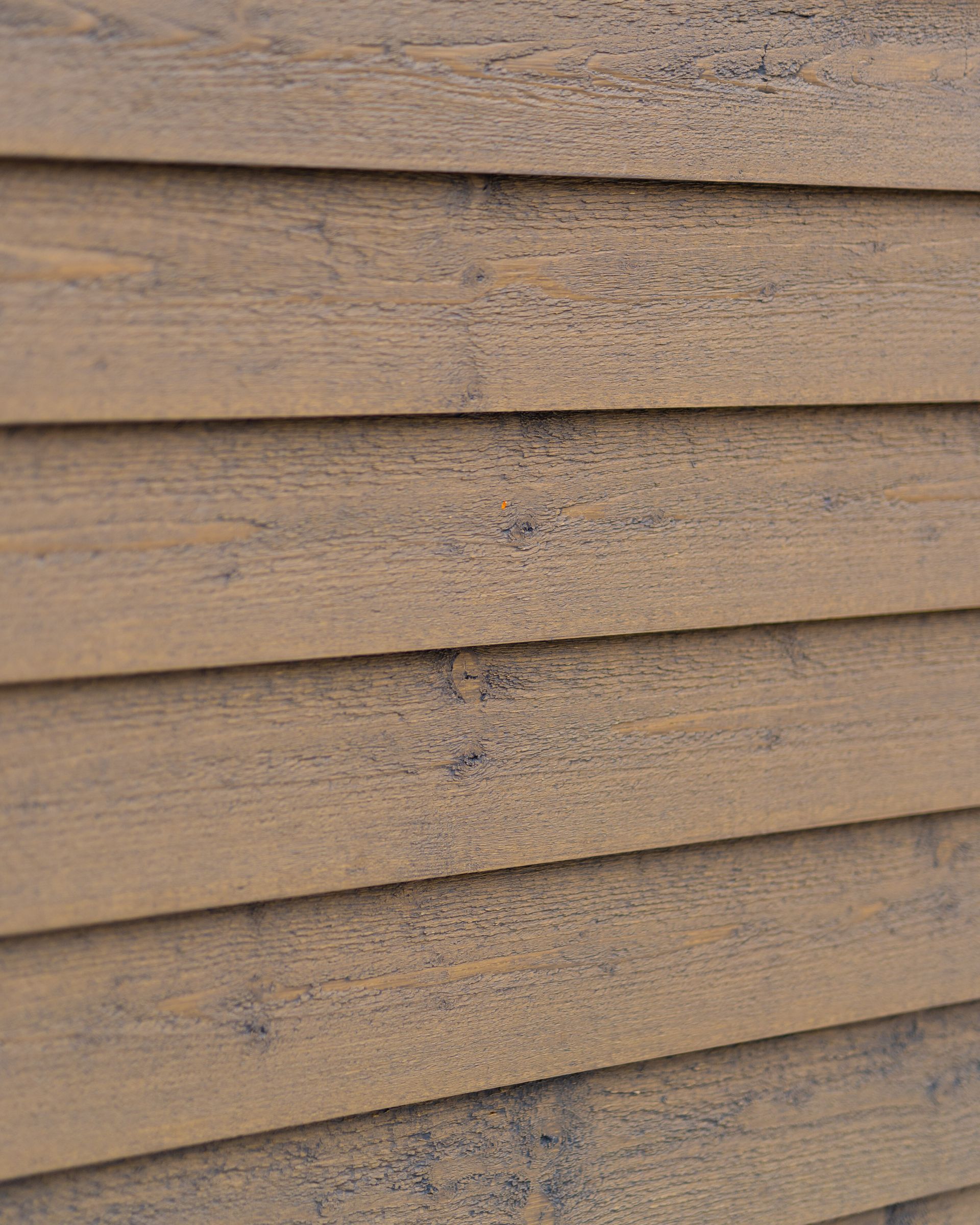 A close up of a wooden siding on a house.