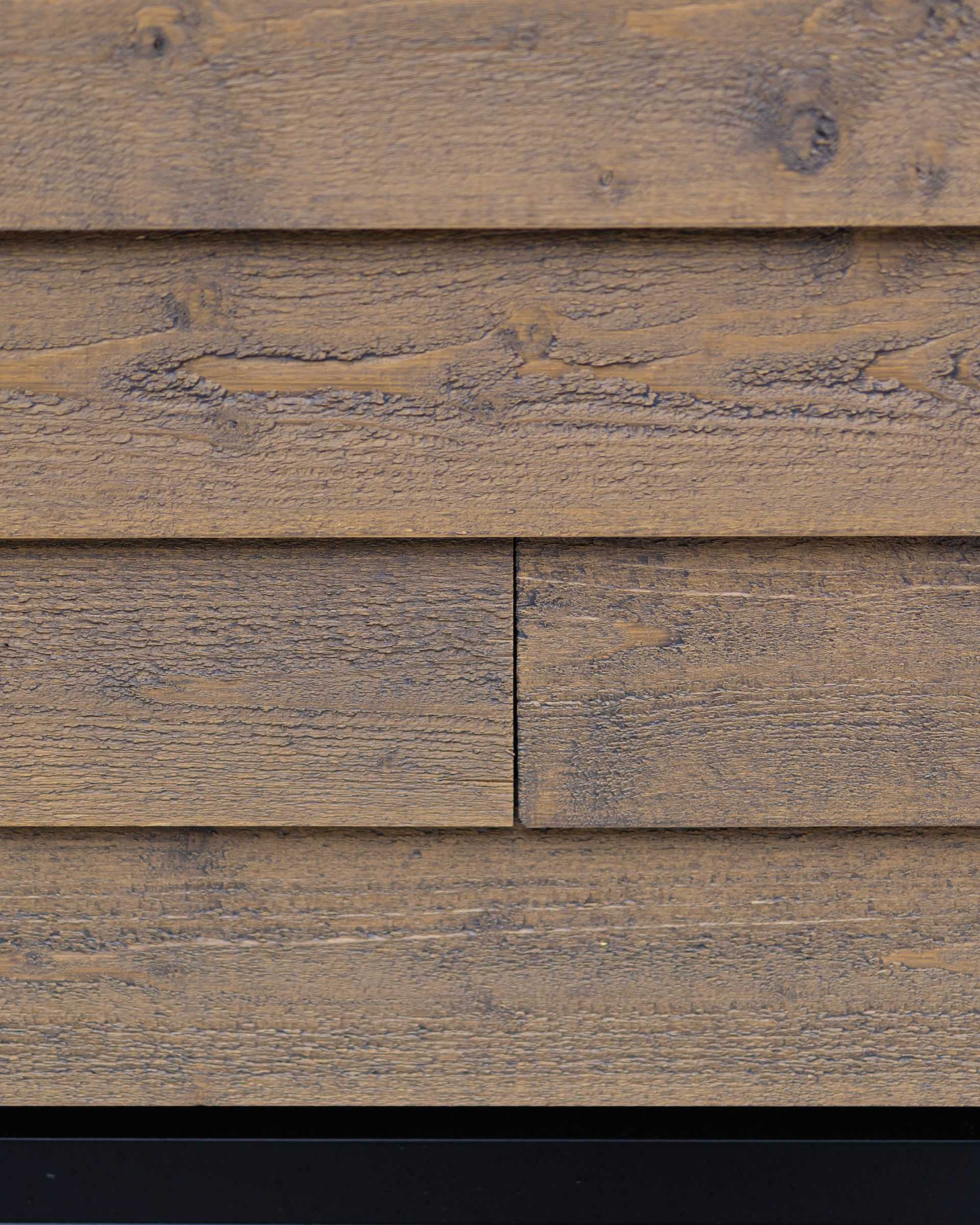 A close up of a wooden wall with a black background.