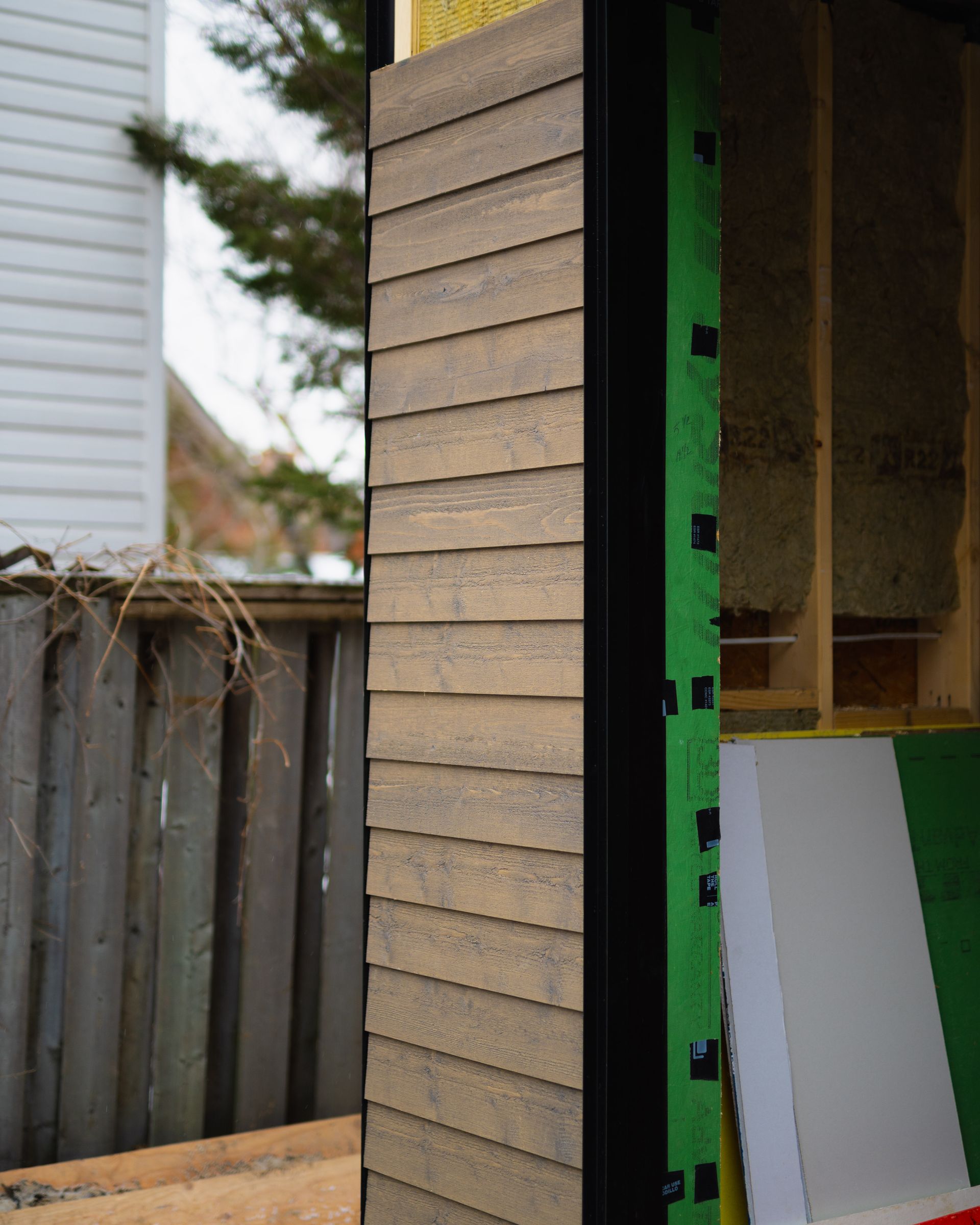 A wooden wall with a green tape on it