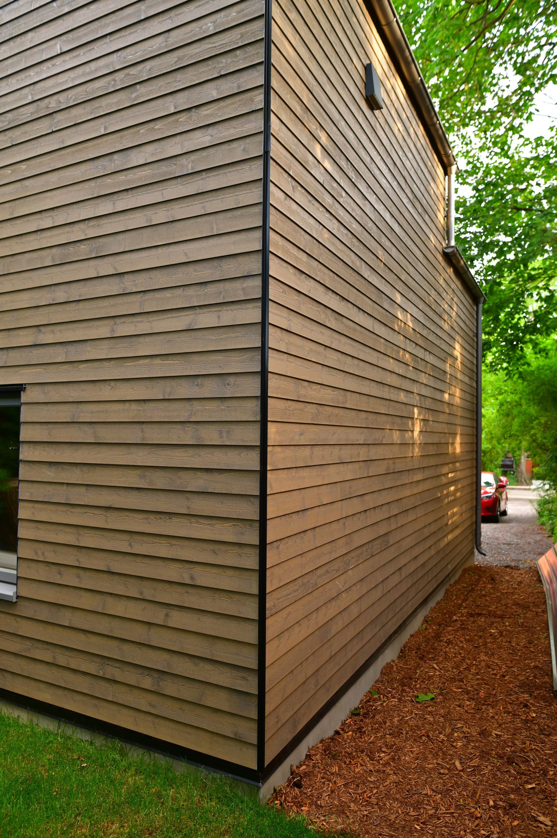 A wooden house with a car parked in front of it