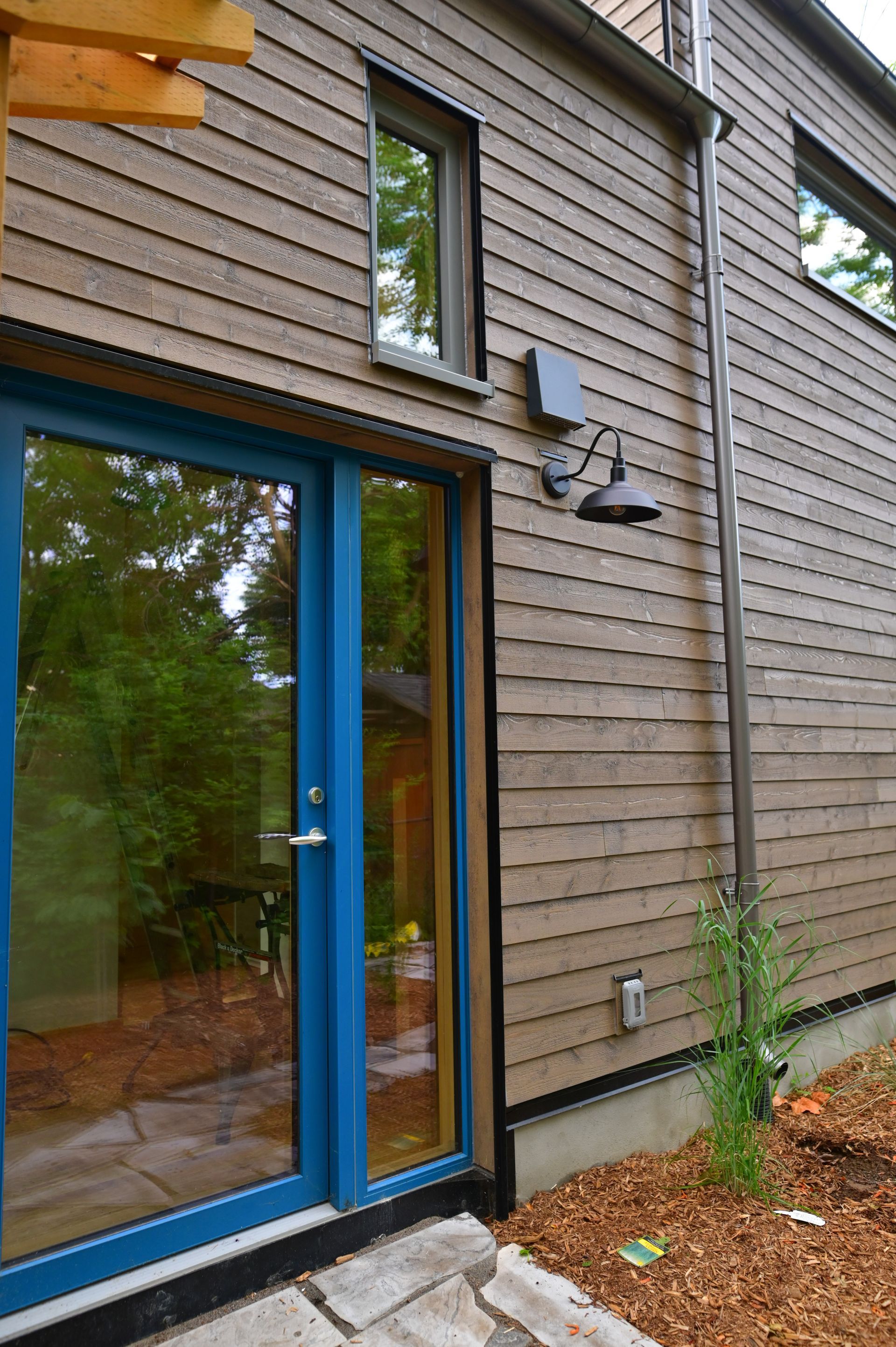 A blue sliding glass door is on the side of a house.