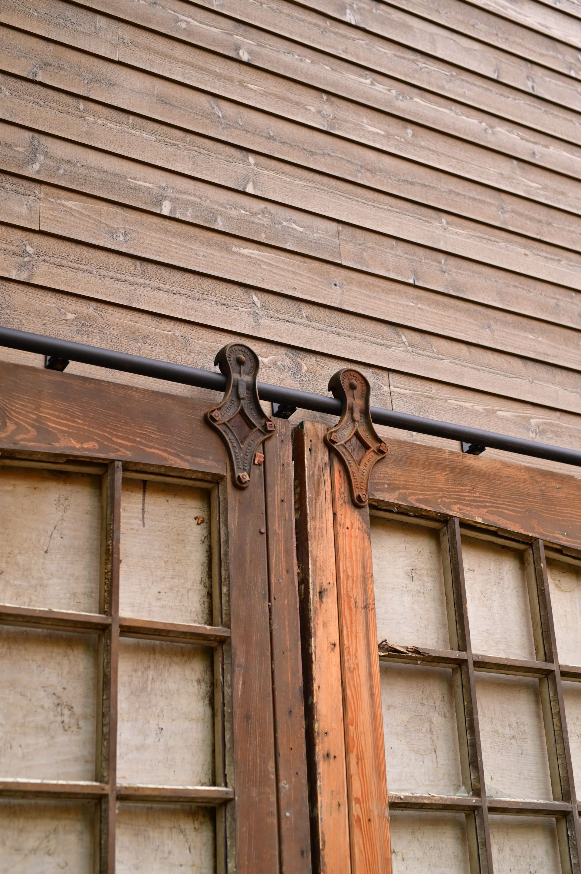 A wooden sliding barn door is hanging on a wooden wall.