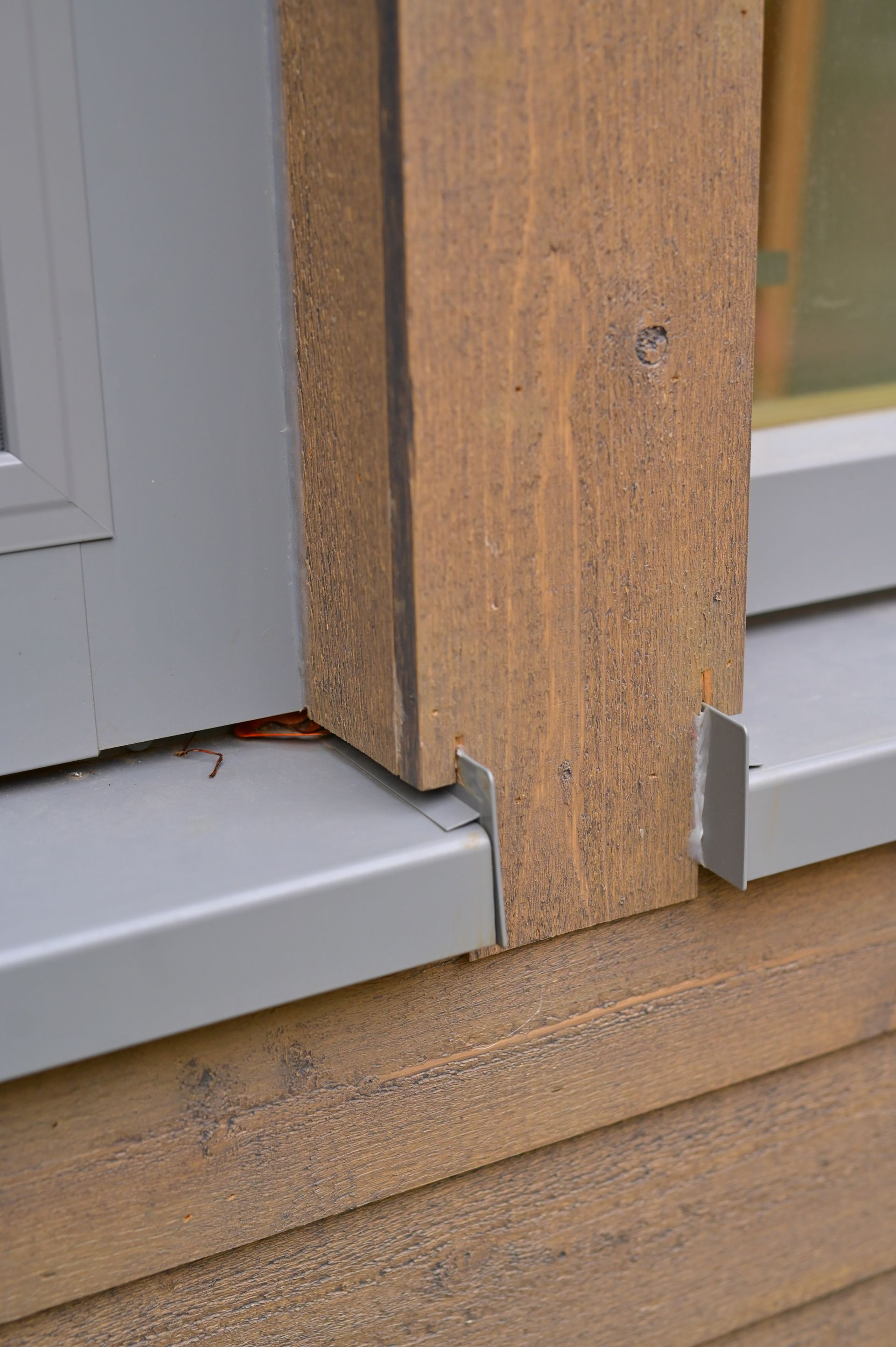 A close up of a window sill on a wooden wall.